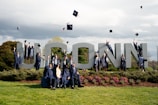 a group of graduates pose for a photo in front of the word lincoln