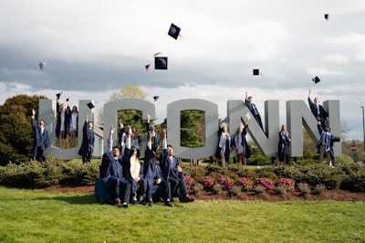 a group of graduates pose for a photo in front of the word lincoln
