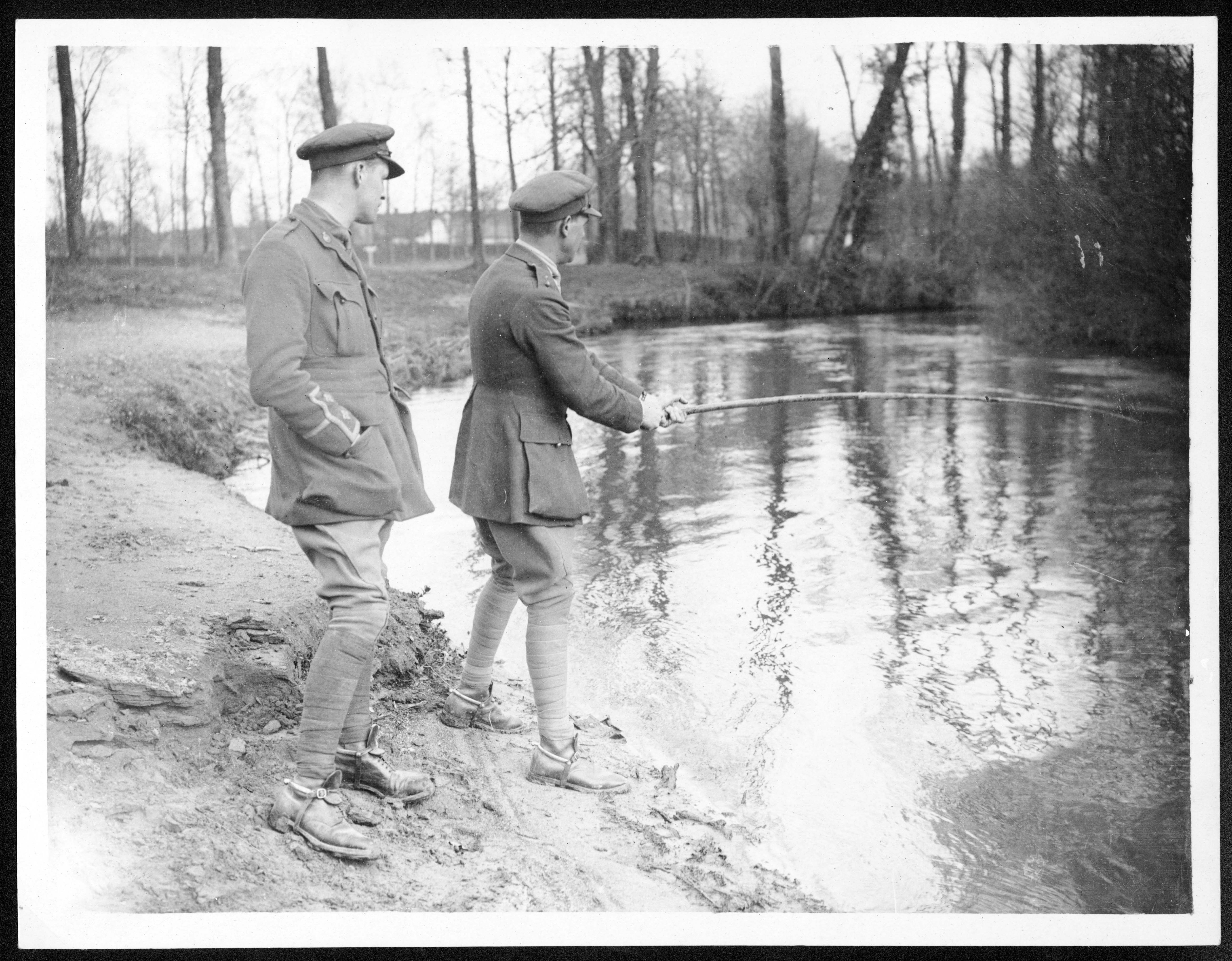 a couple of men standing next to a river