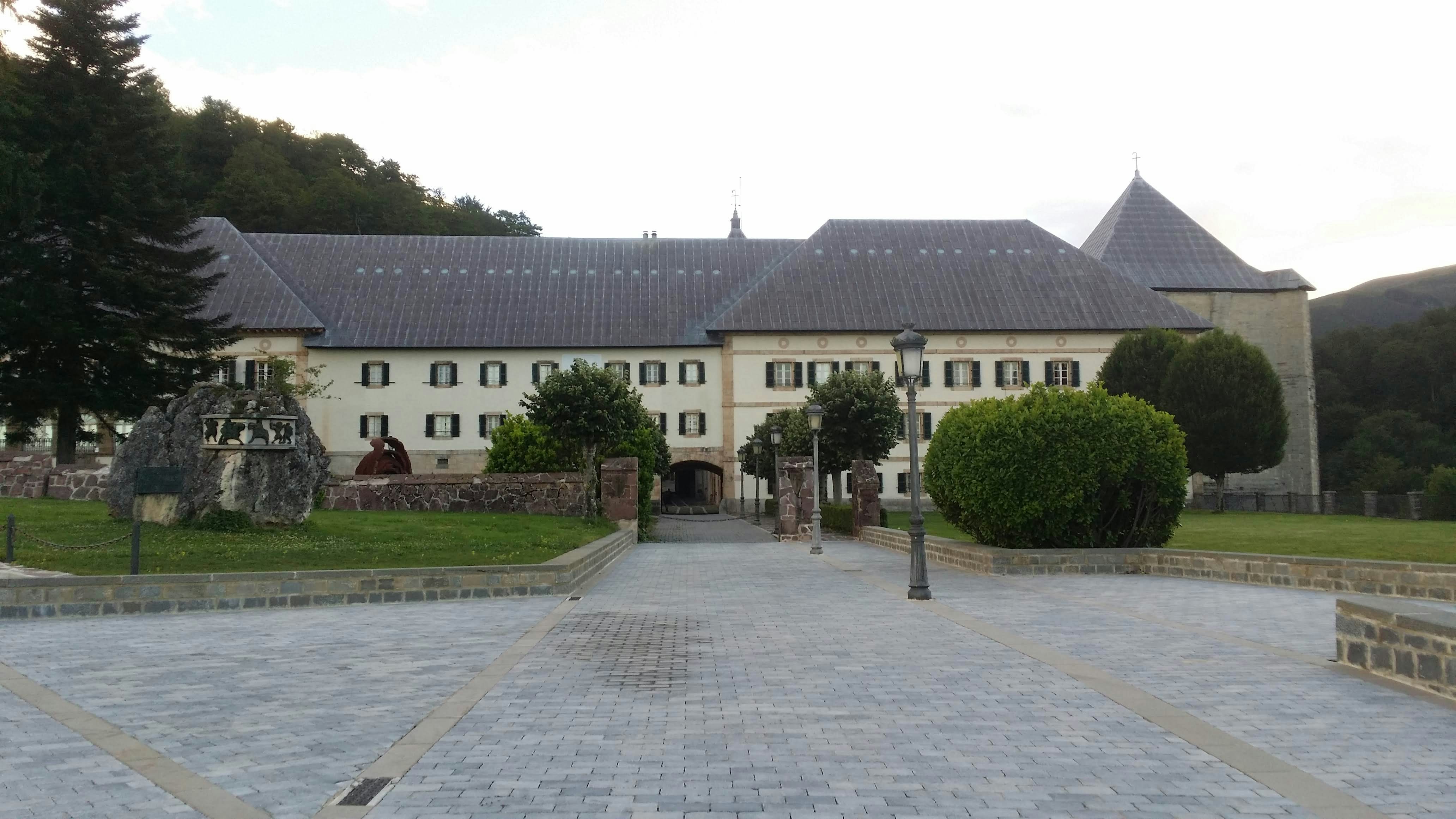 a large white building with a lot of trees in front of it