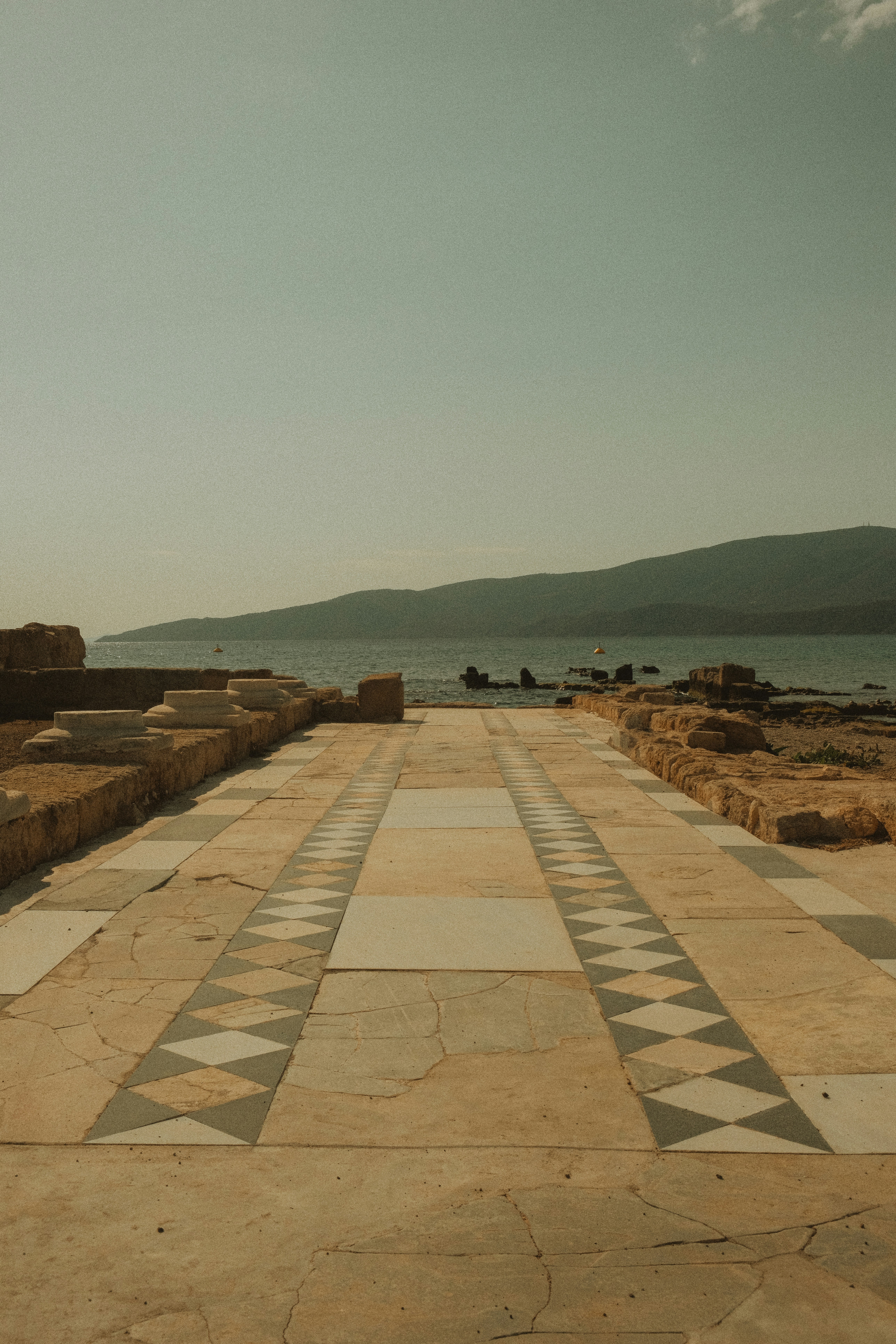 a bench sitting on the side of a road next to a body of water
