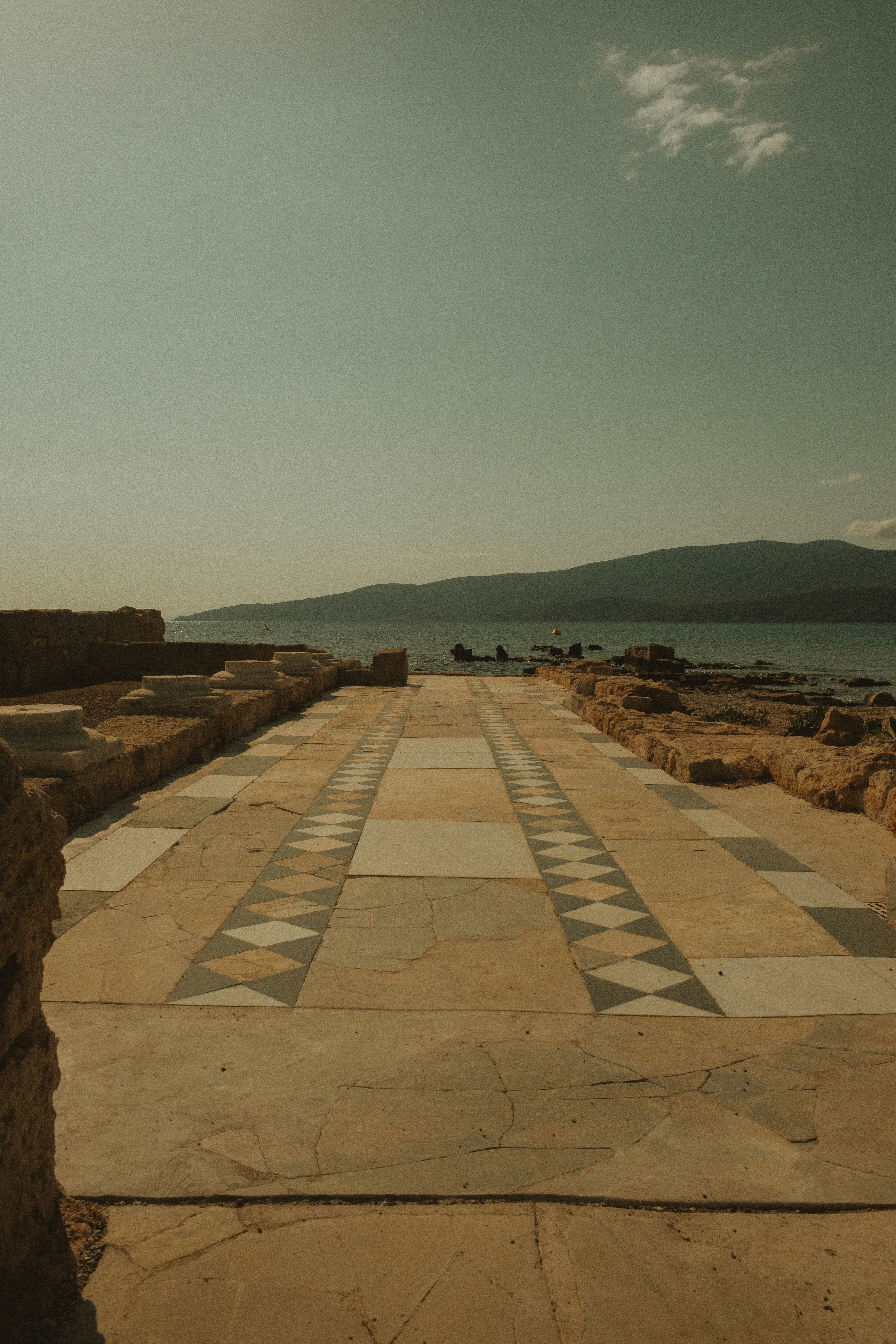a bench sitting on the side of a road next to a body of water