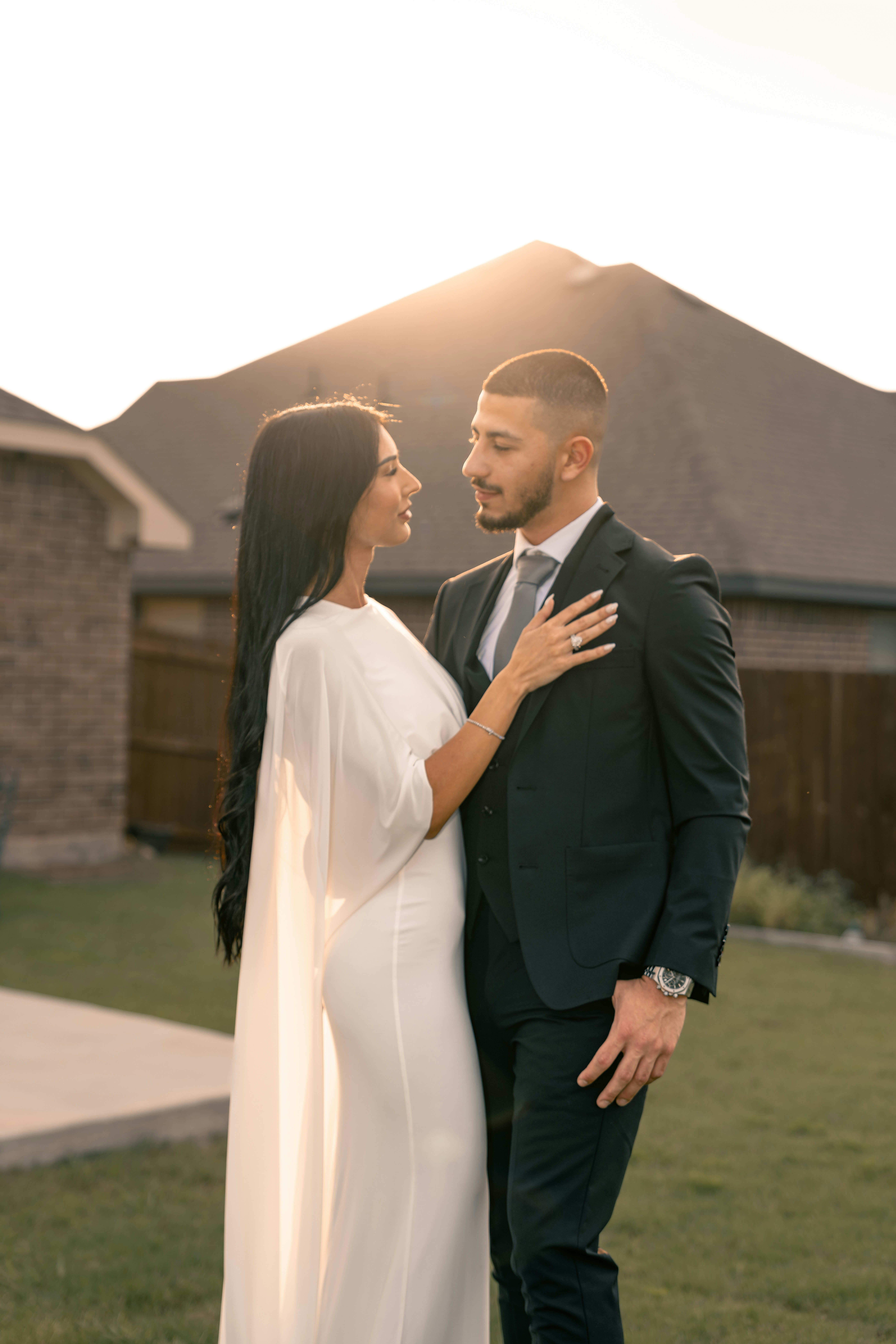 a man and a woman standing in front of a house