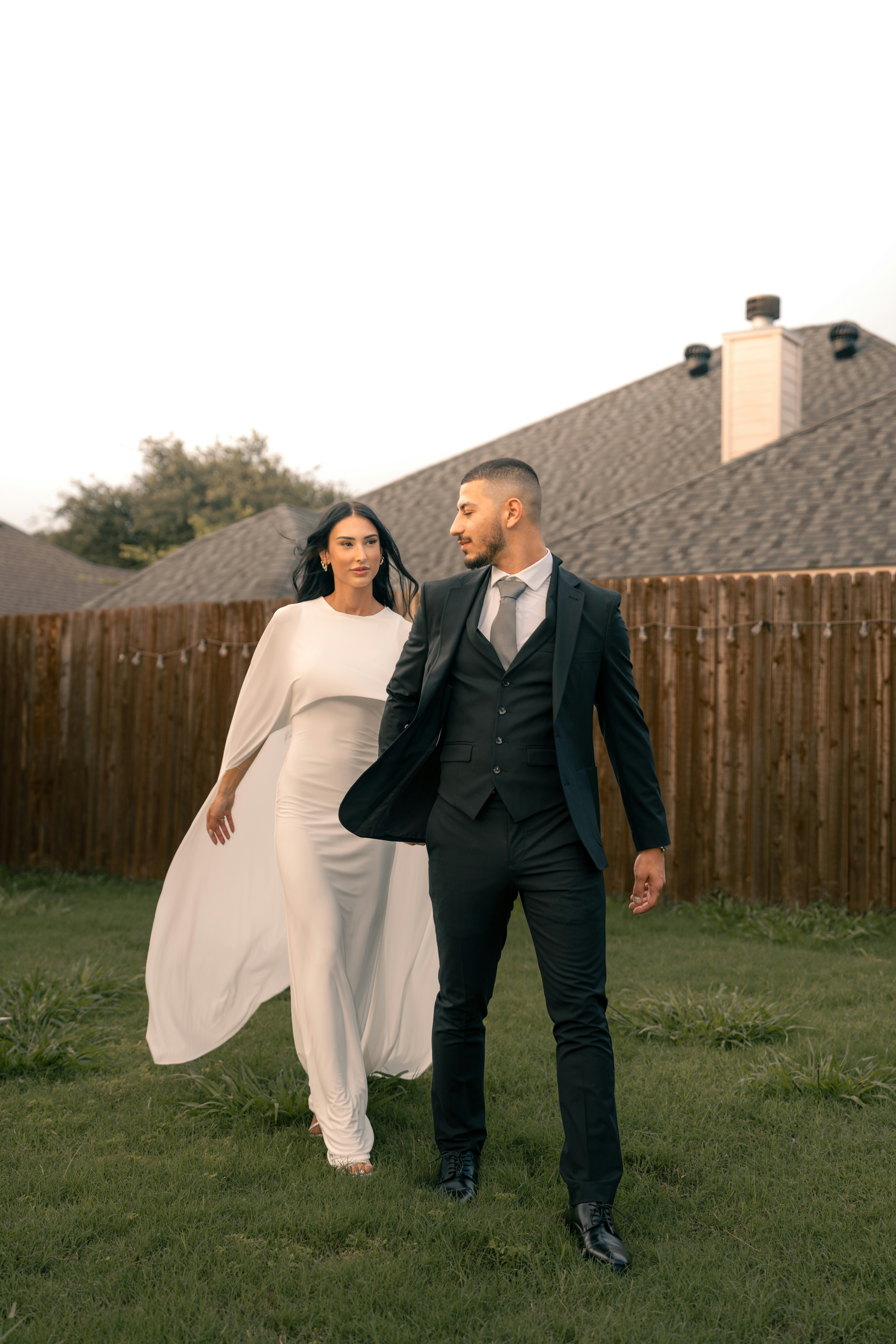 a man and a woman walking in the grass