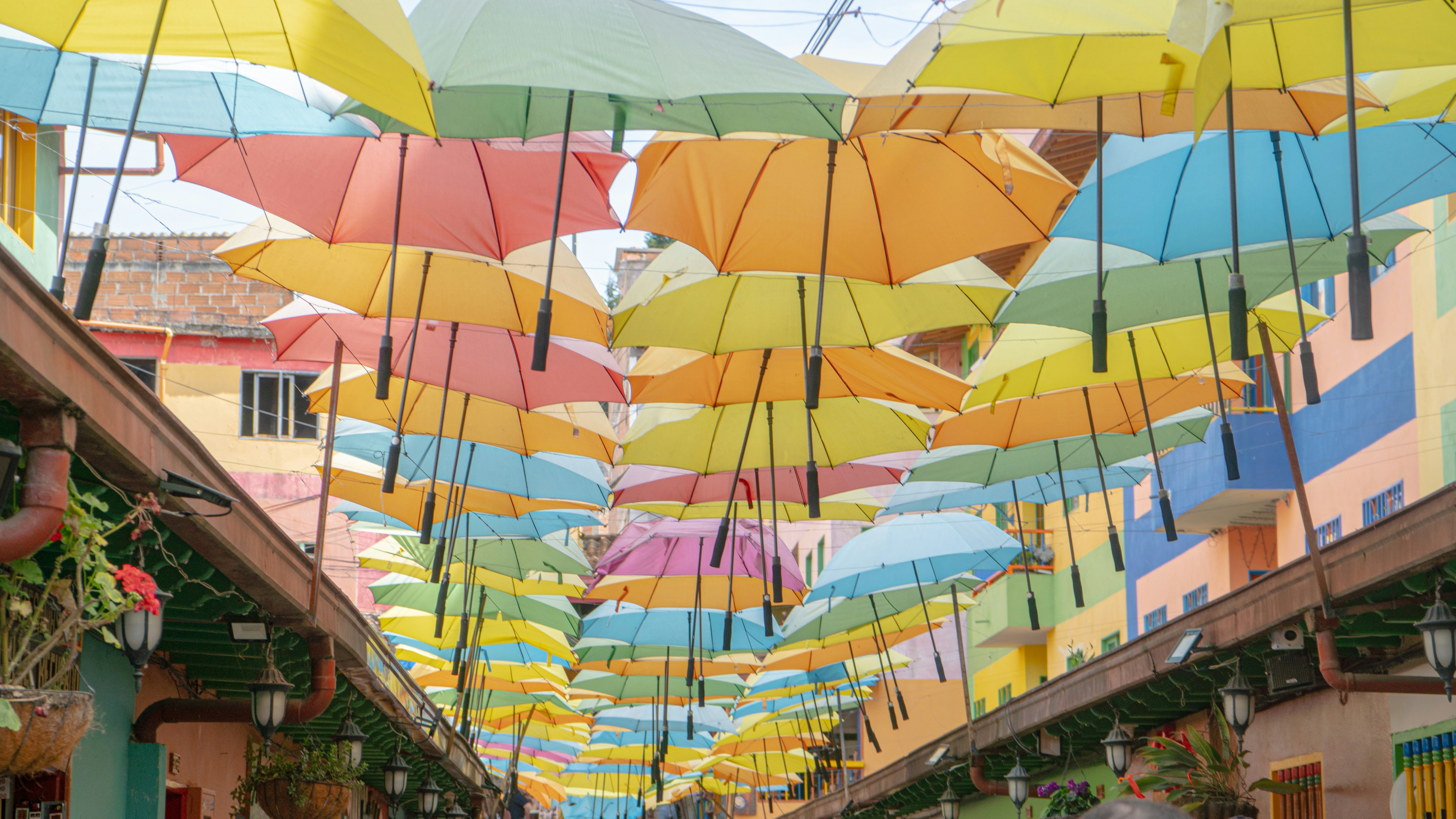 many umbrellas are hanging from the ceiling of a street