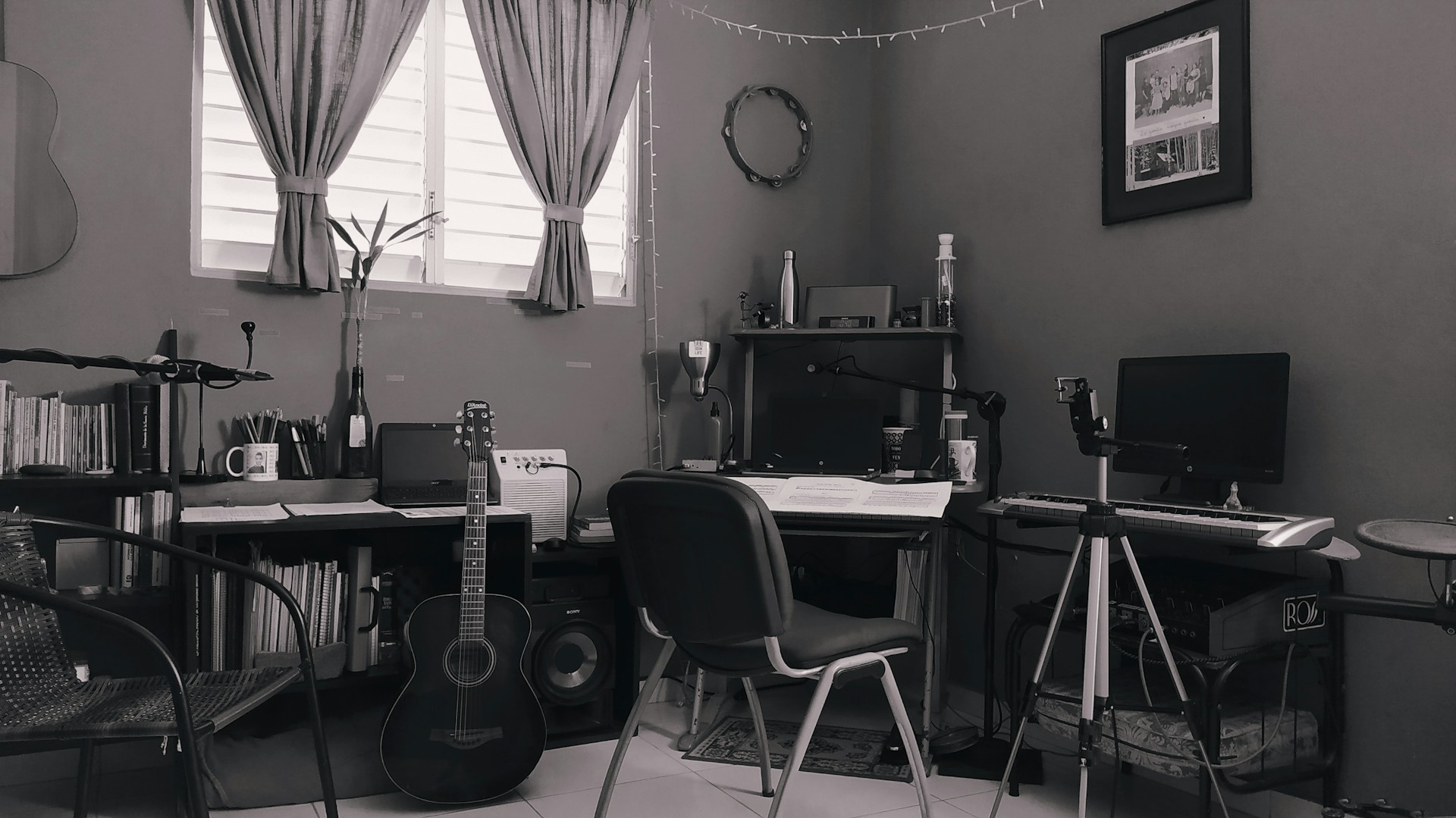 a black and white photo of a desk with a guitar