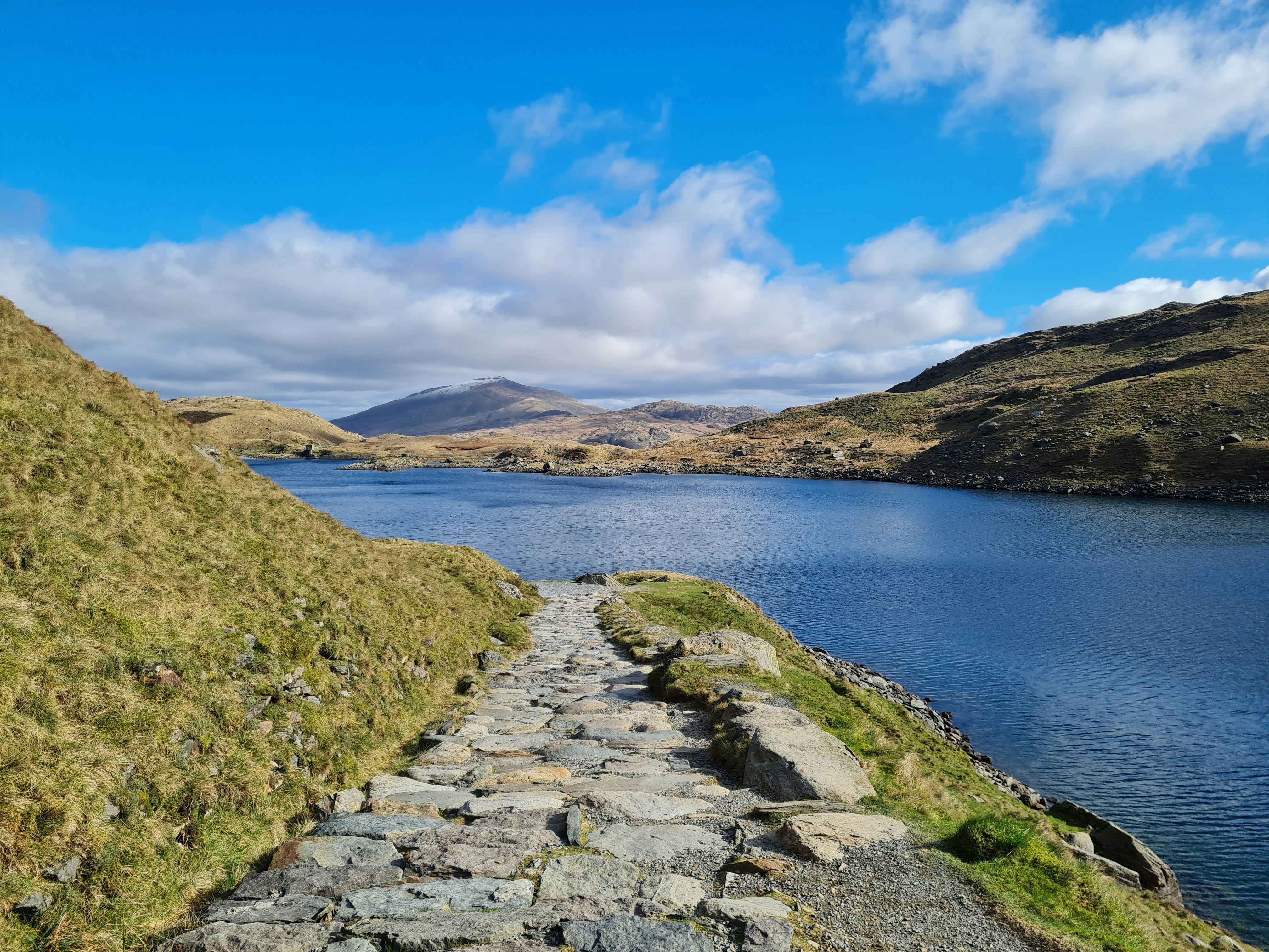 a stone path next to a body of water