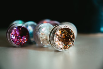 a close up of three glitter bottles on a table