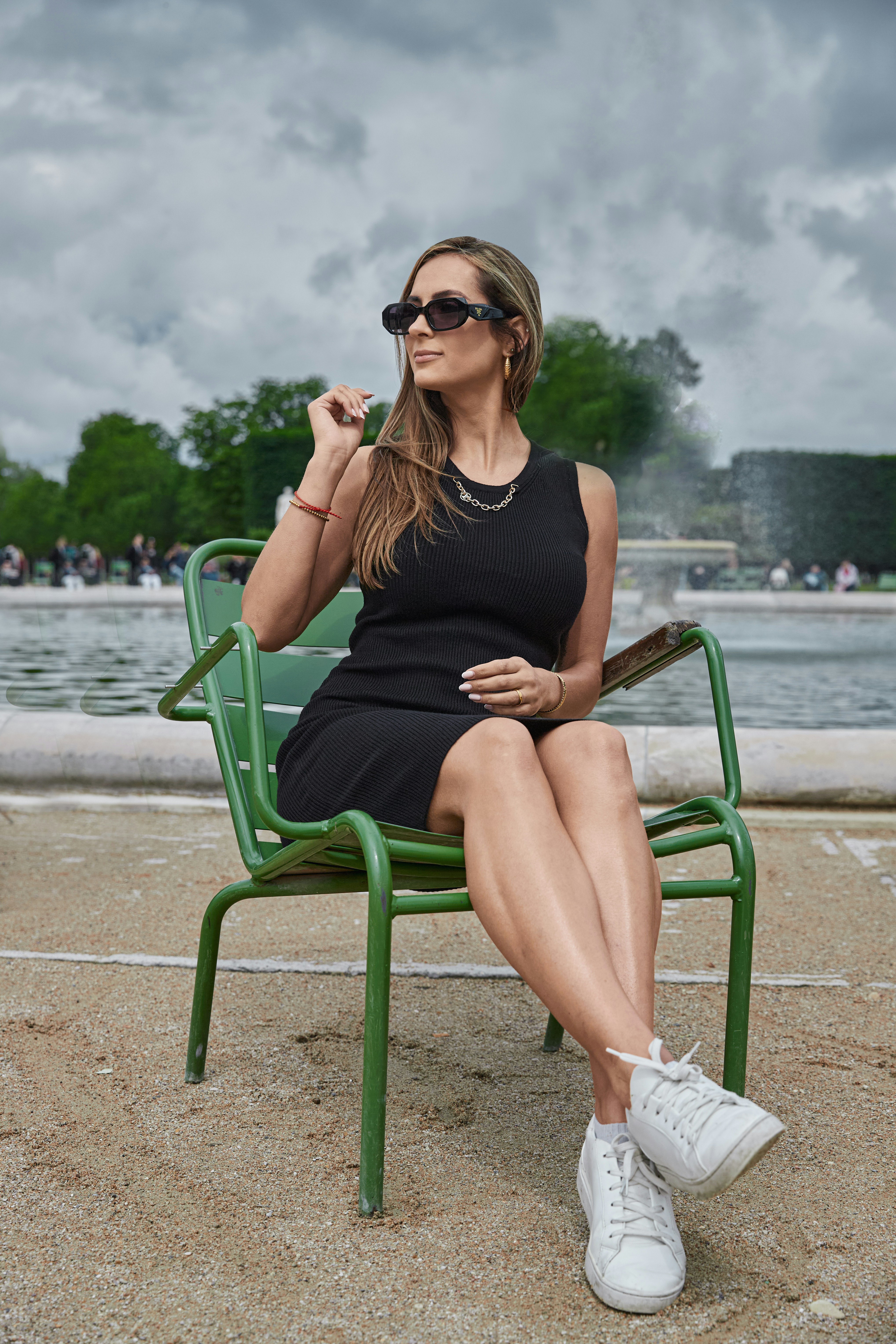 a woman in a black dress sitting on a green chair