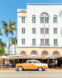 an orange and white car parked in front of a building