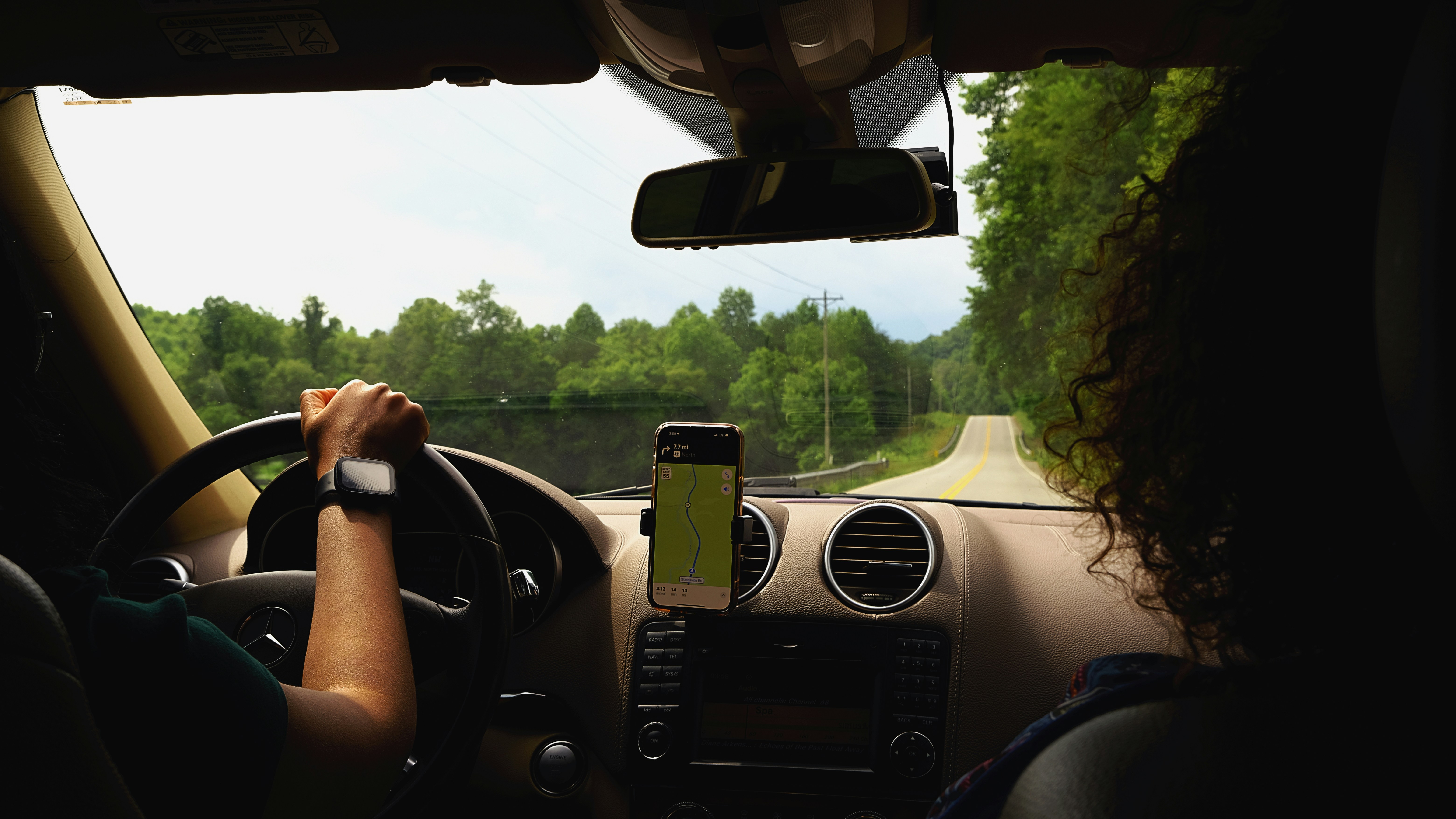 a woman driving a car with a cell phone in her hand