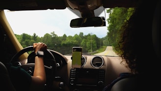a woman driving a car with a cell phone in her hand