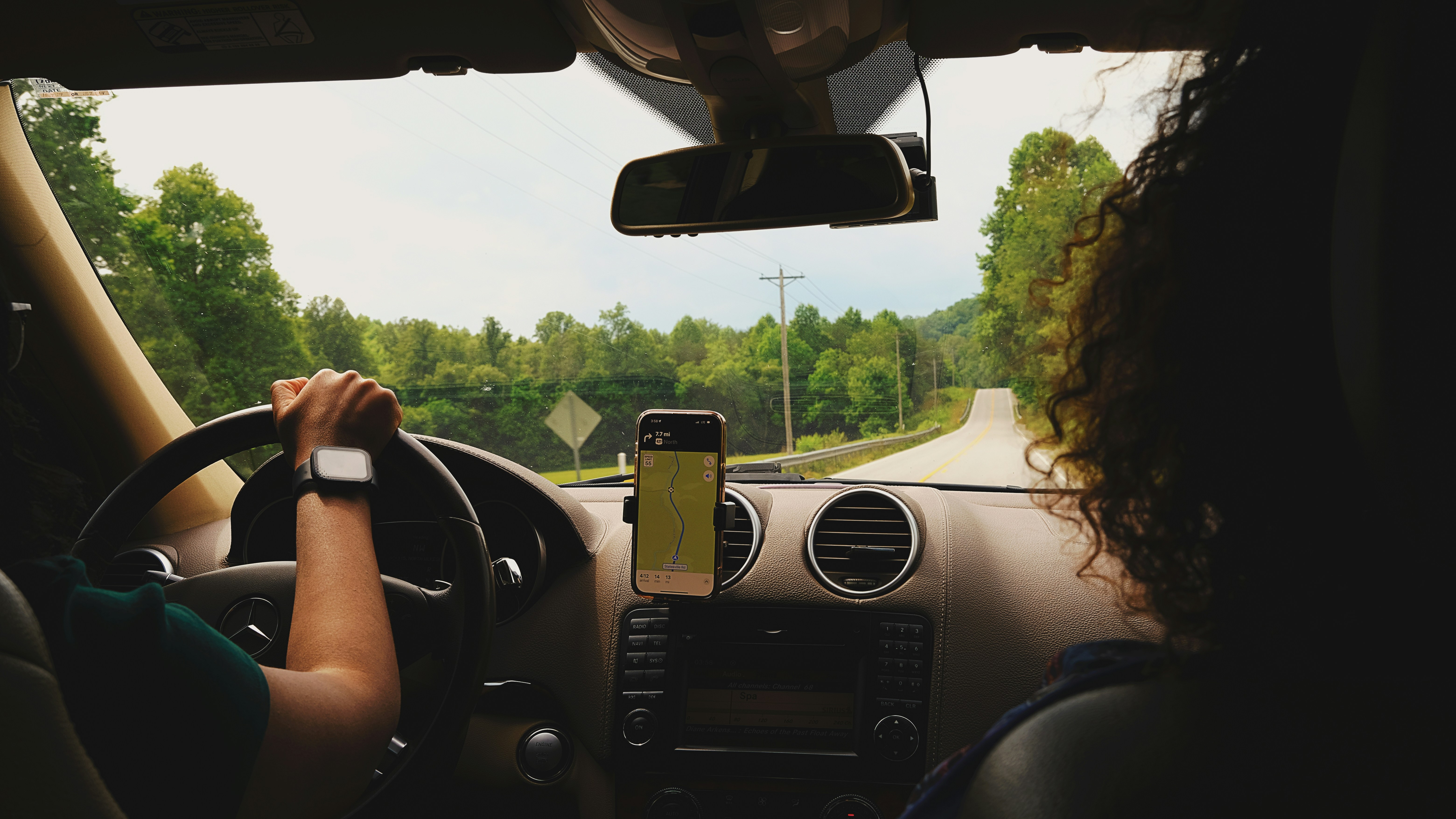 a woman driving a car while holding a cell phone