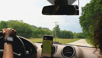 a woman driving a car with a cell phone in her hand