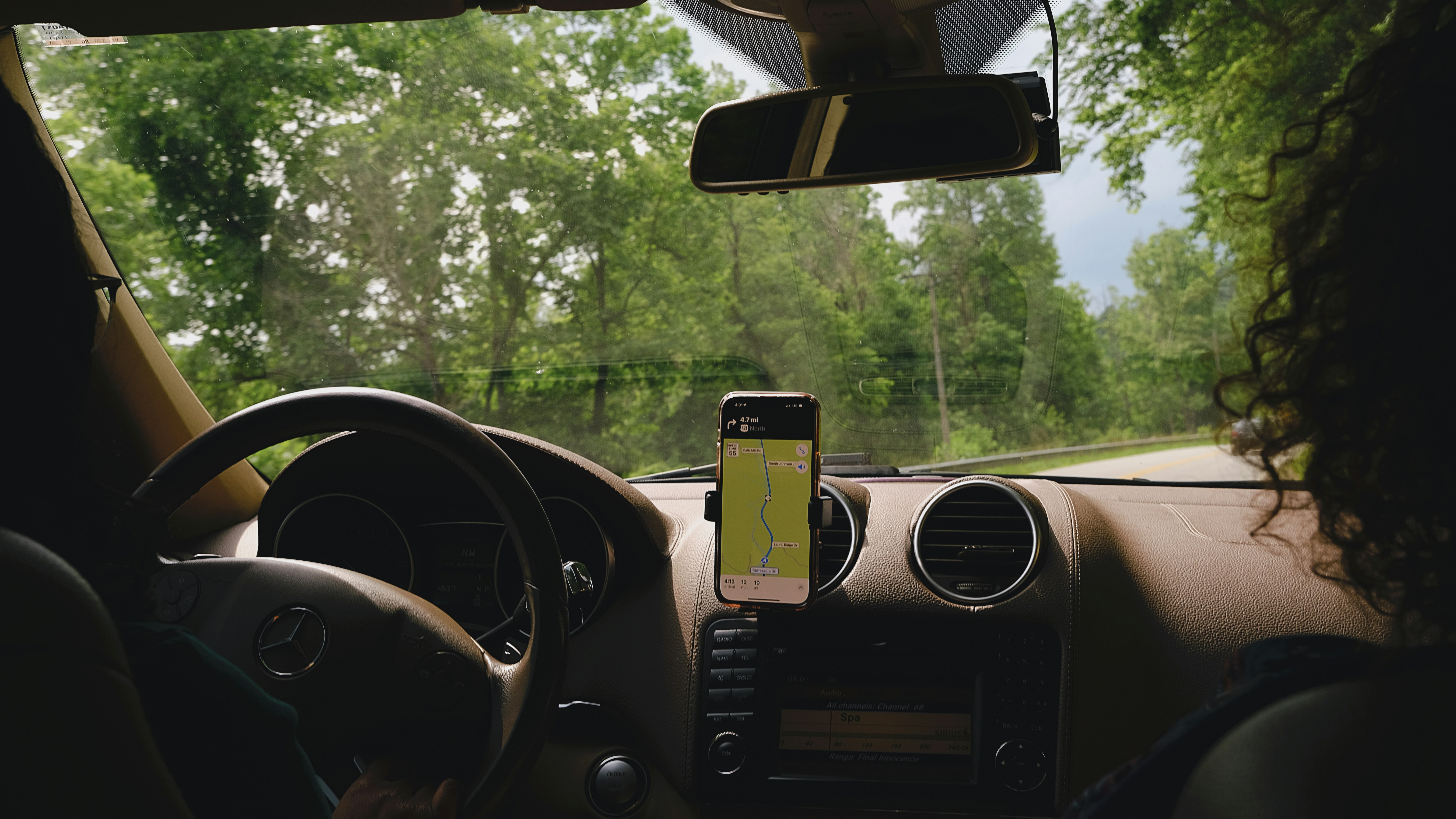a woman driving a car with a cell phone in her hand