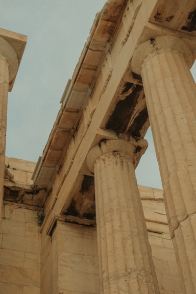 a close up of two stone pillars with a blue sky in the background
