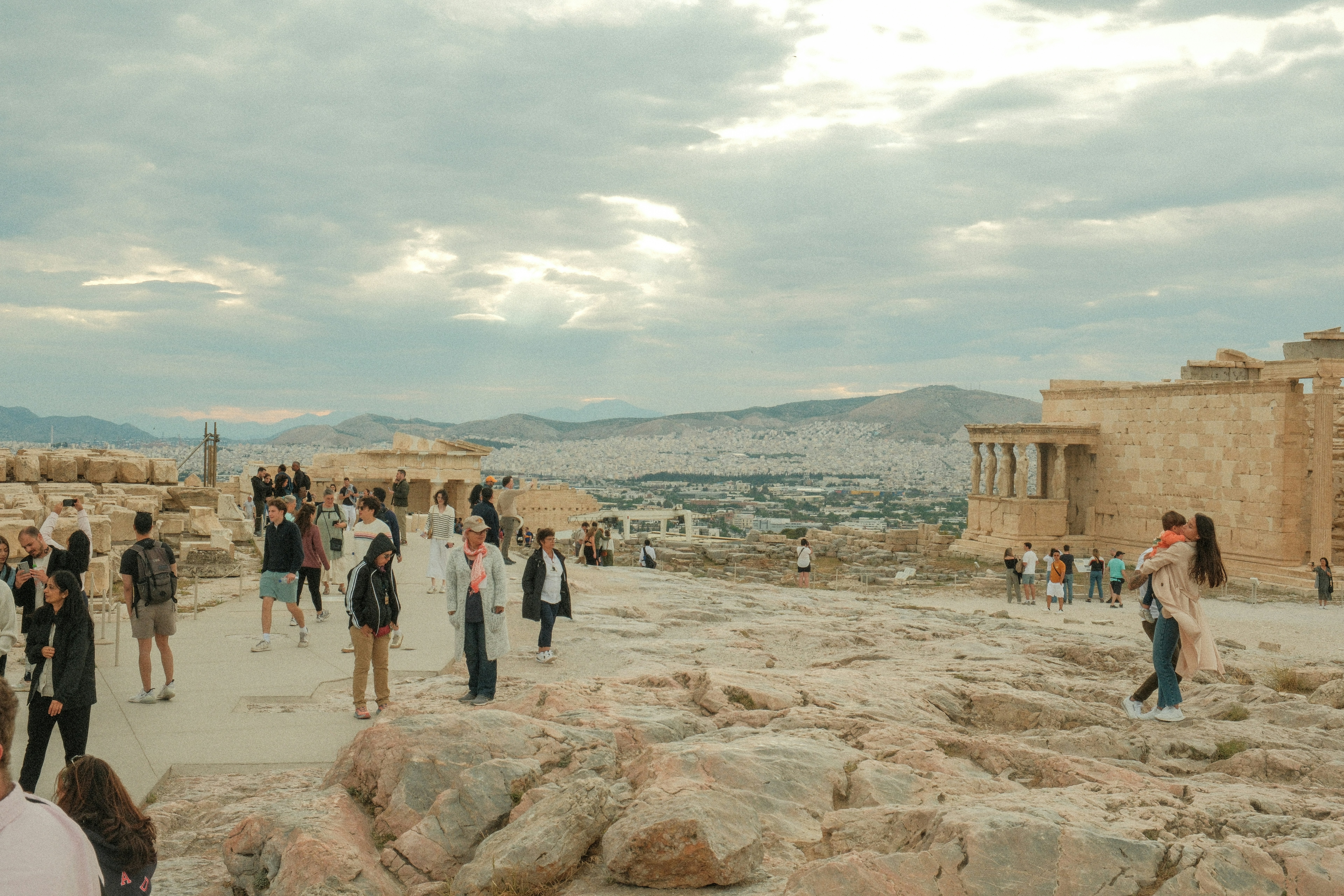 a group of people standing on top of a rocky hillside, 