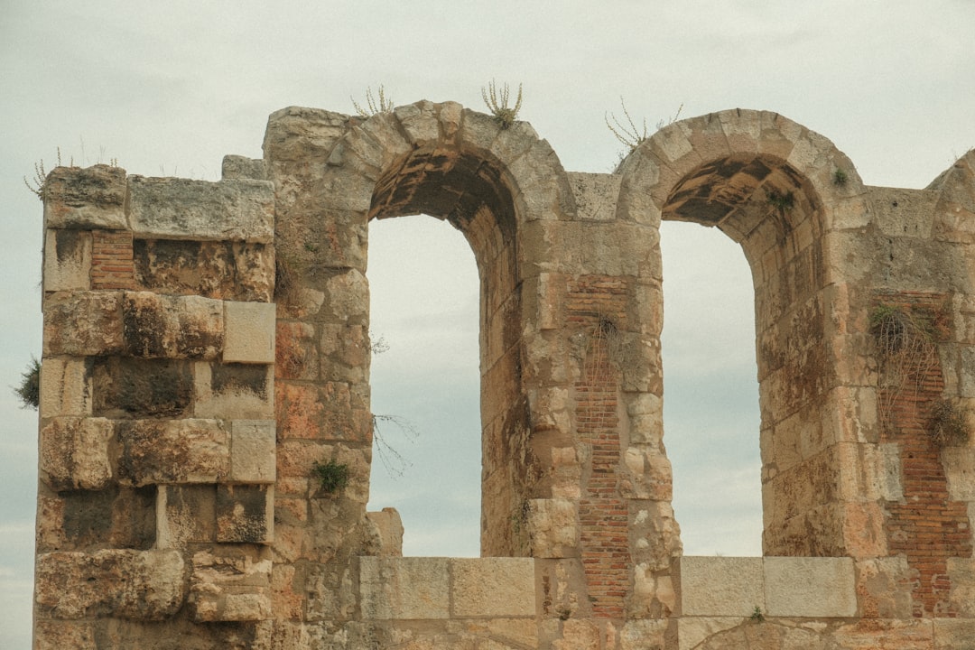 an old stone building with two arched windows,