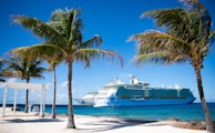 a cruise ship is docked at a tropical beach