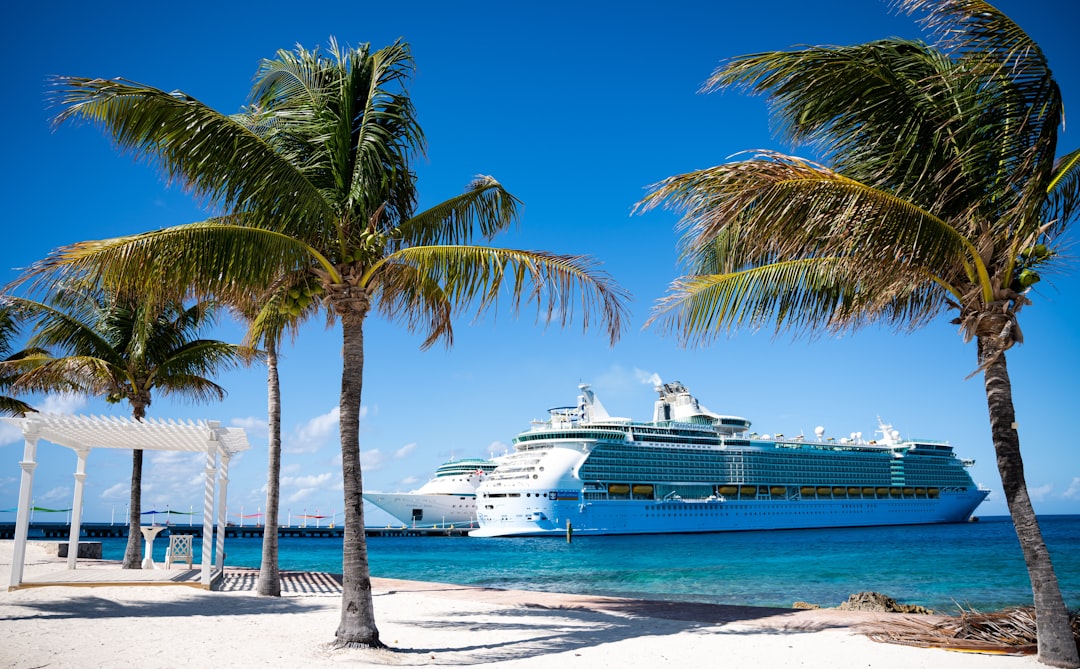 a cruise ship is docked at a tropical beach, The Royalness of the Carribean.