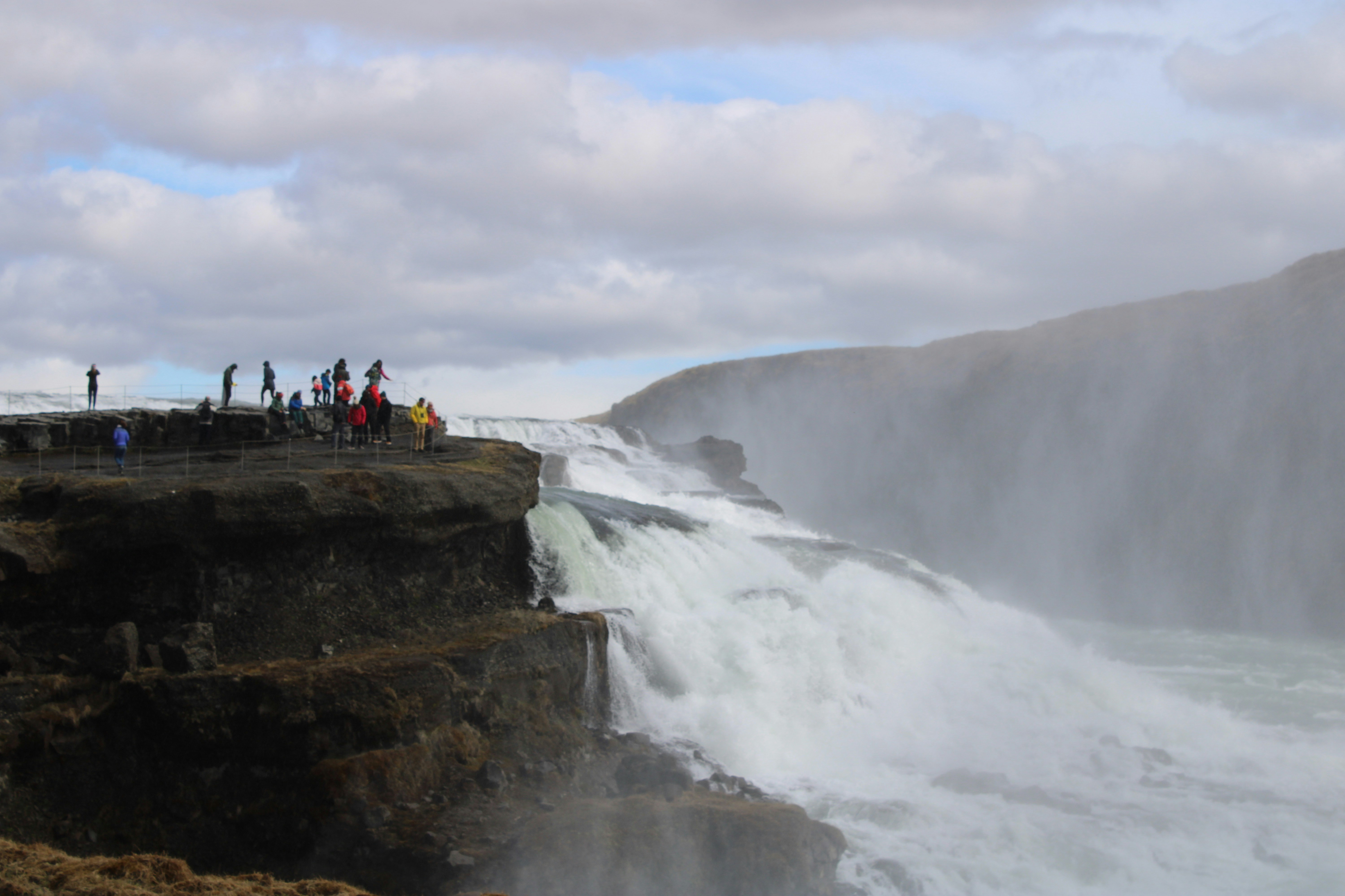 a group of people standing at the edge of a waterfall