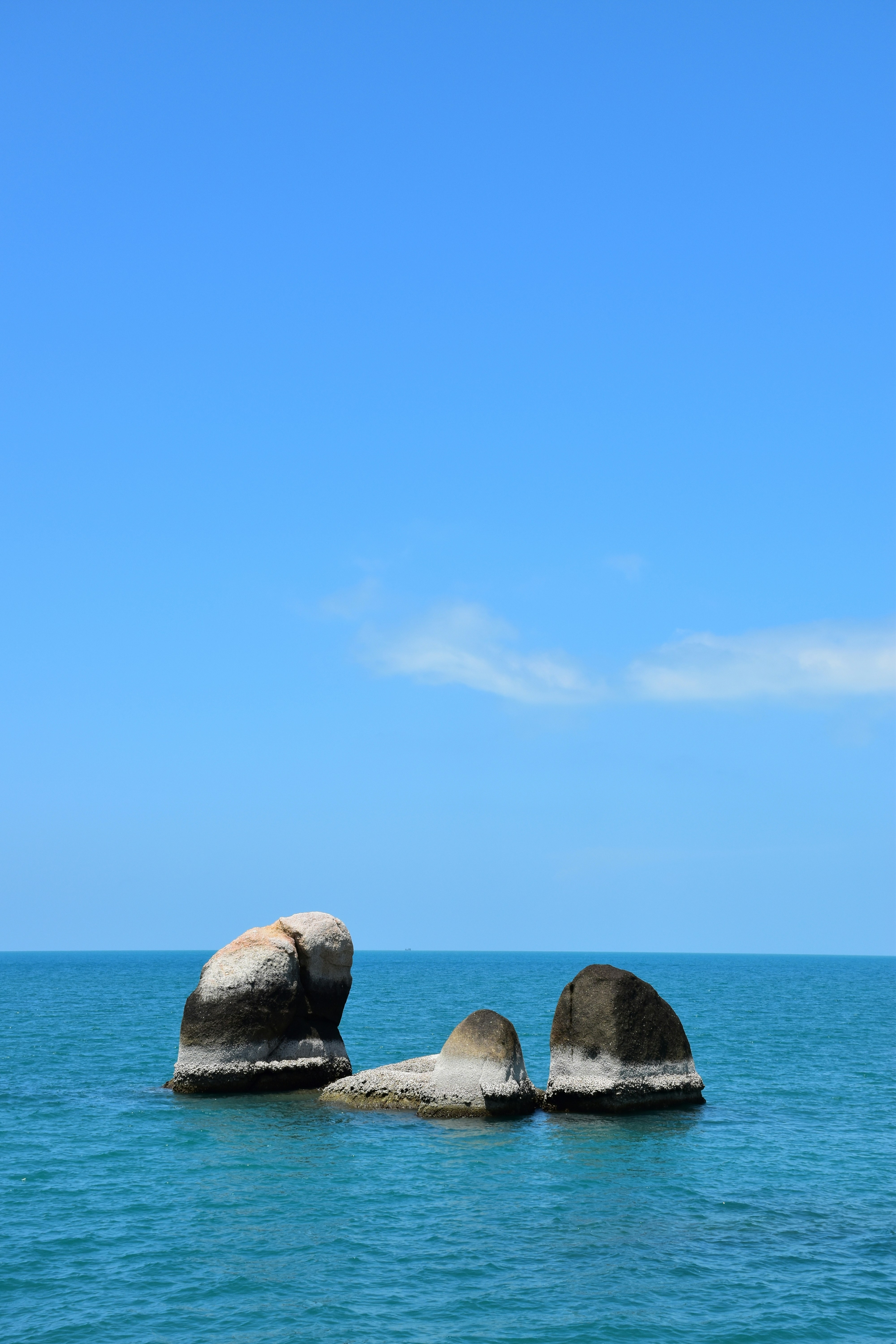 Two large rocks sticking out of the ocean photo – Free Sky Image on ...