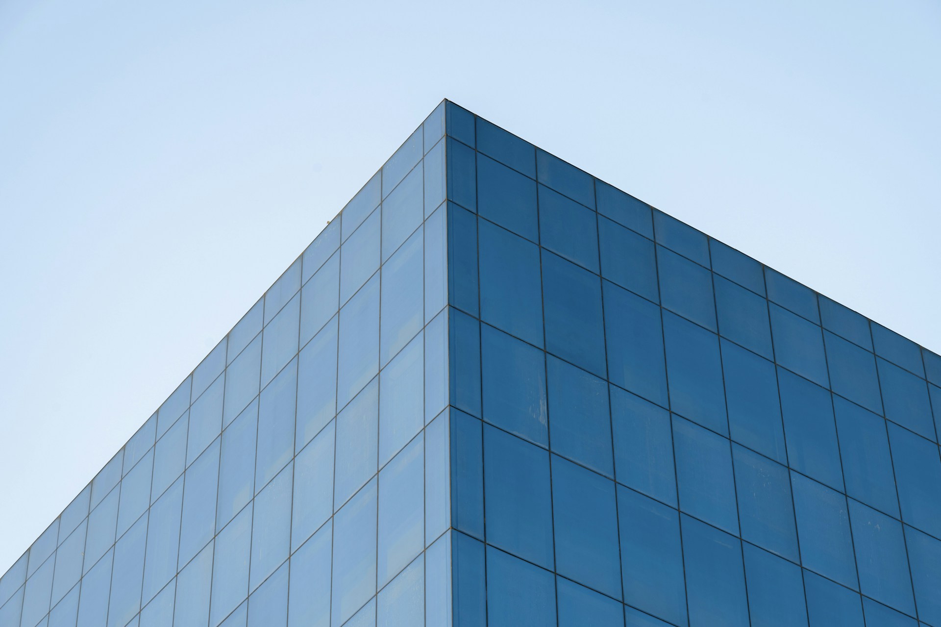 a tall blue building with a sky in the background