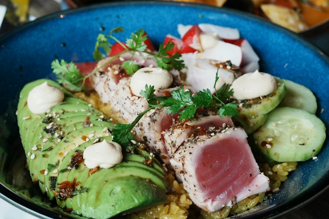 A blue bowl filled with meat and vegetables