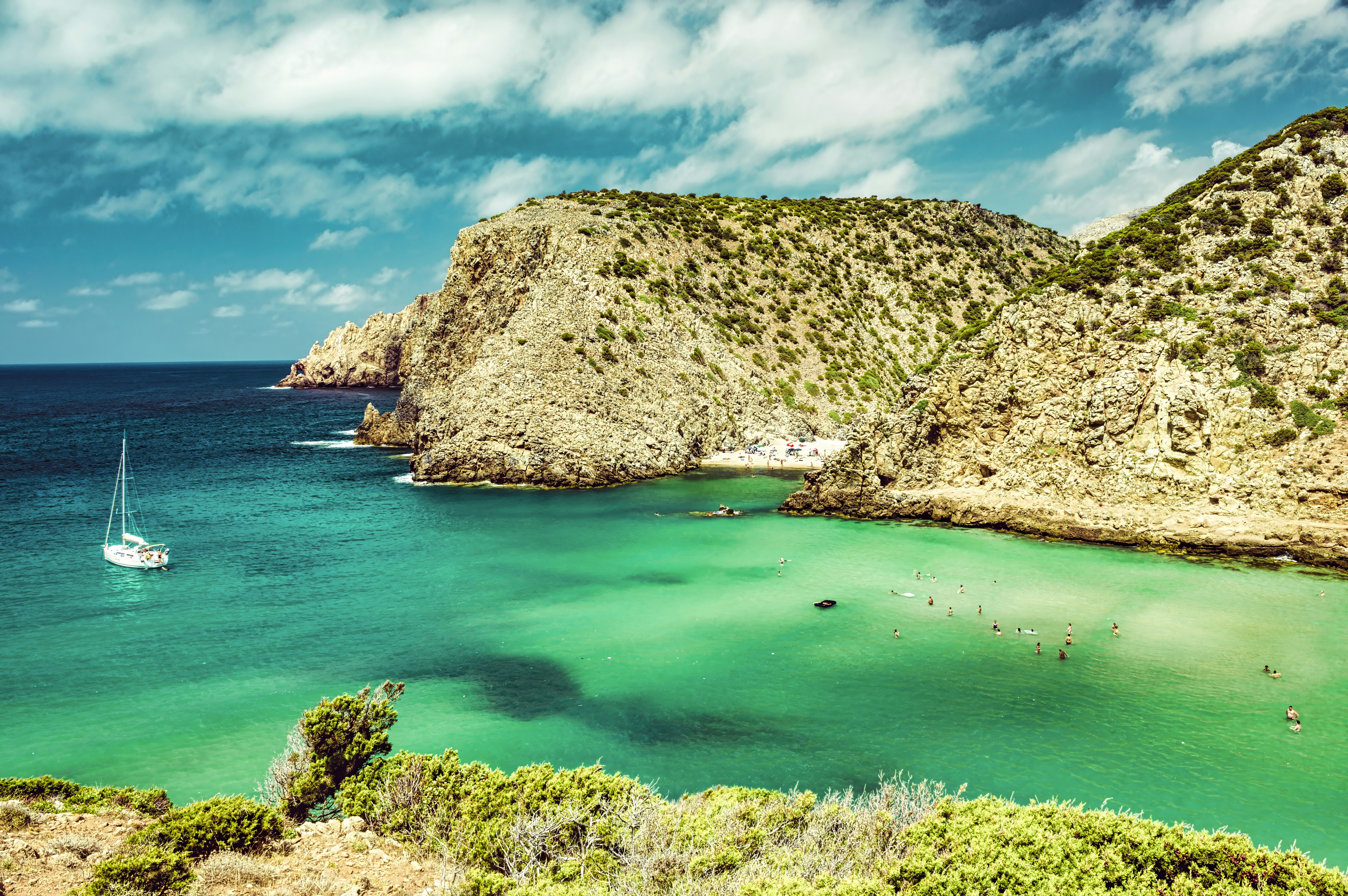 a boat is in the water near a rocky shore