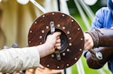 a person holding a sword with another person's hand