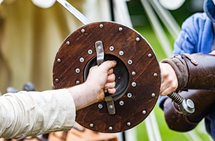 a person holding a sword with another person's hand
