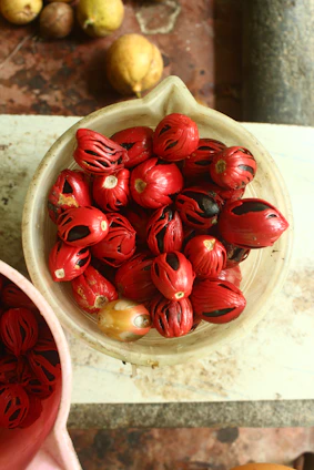 a bowl filled with red fruit sitting on top of a table