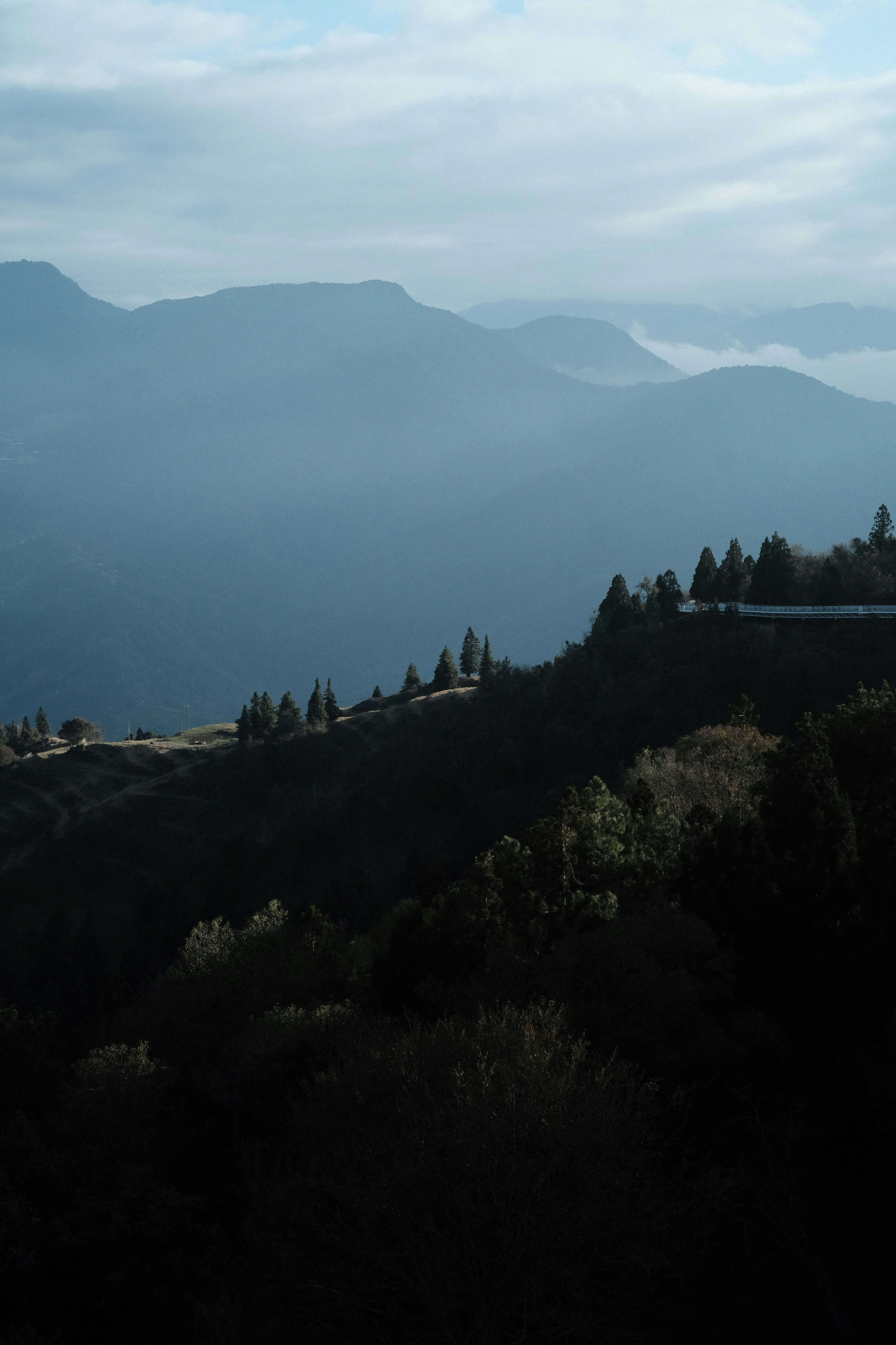 a view of a mountain range with trees and mountains in the background