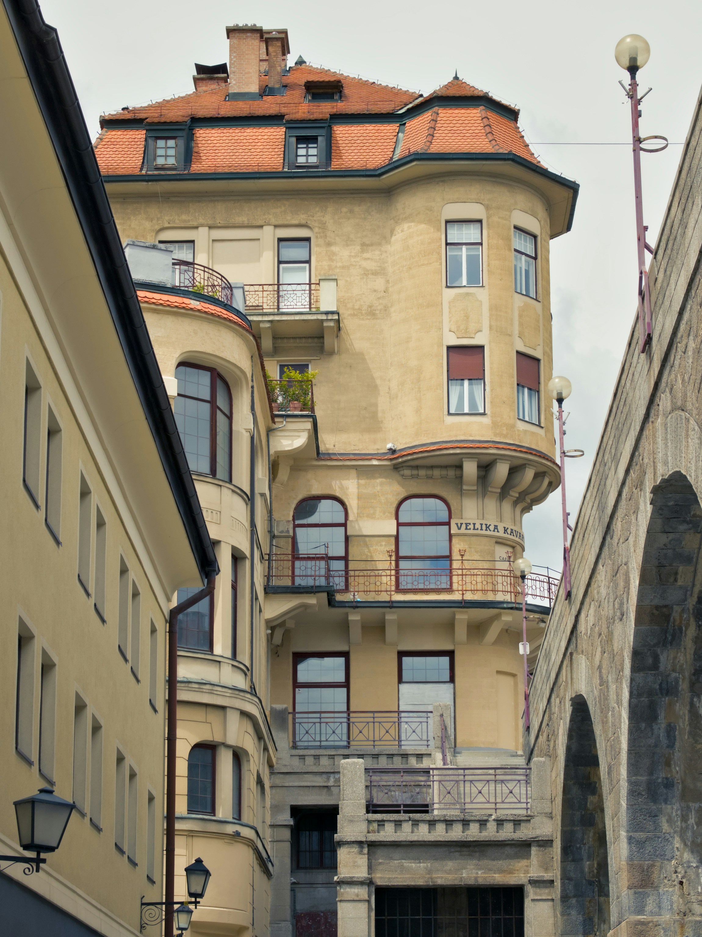 un edificio alto con un tetto rosso accanto a un ponte