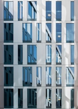 a tall building with lots of windows next to a street