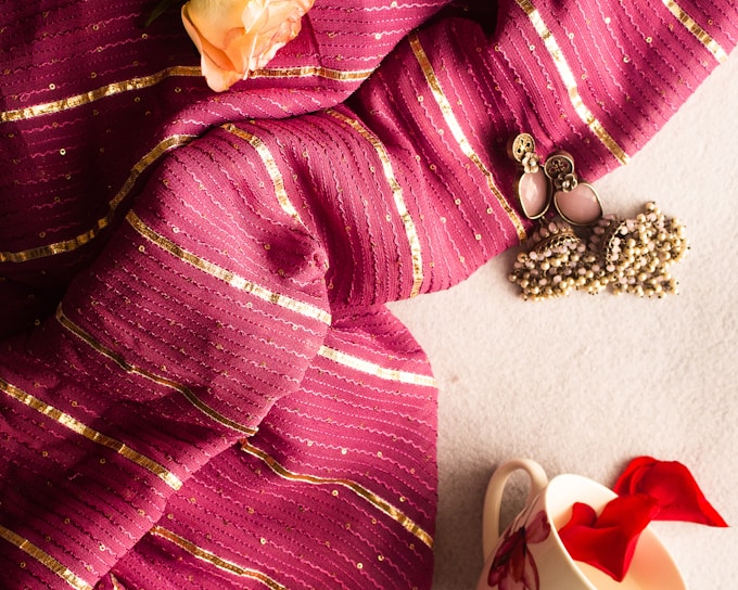 a close up of a scarf with a flower on it