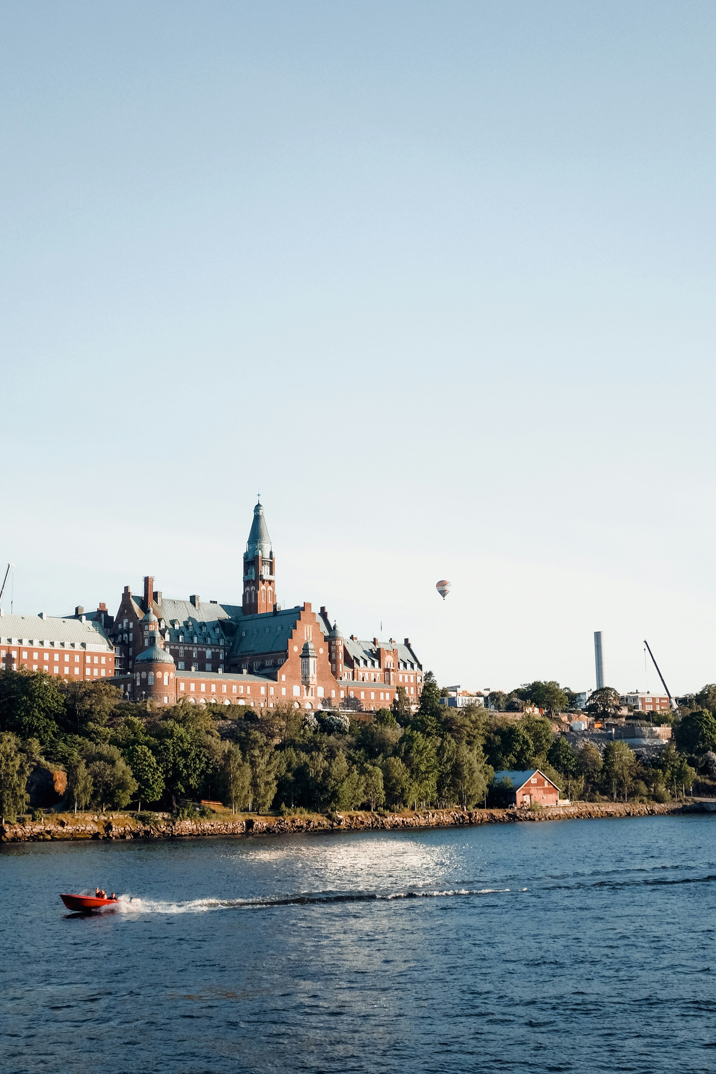 um barco descendo um rio ao lado de um grande edifício