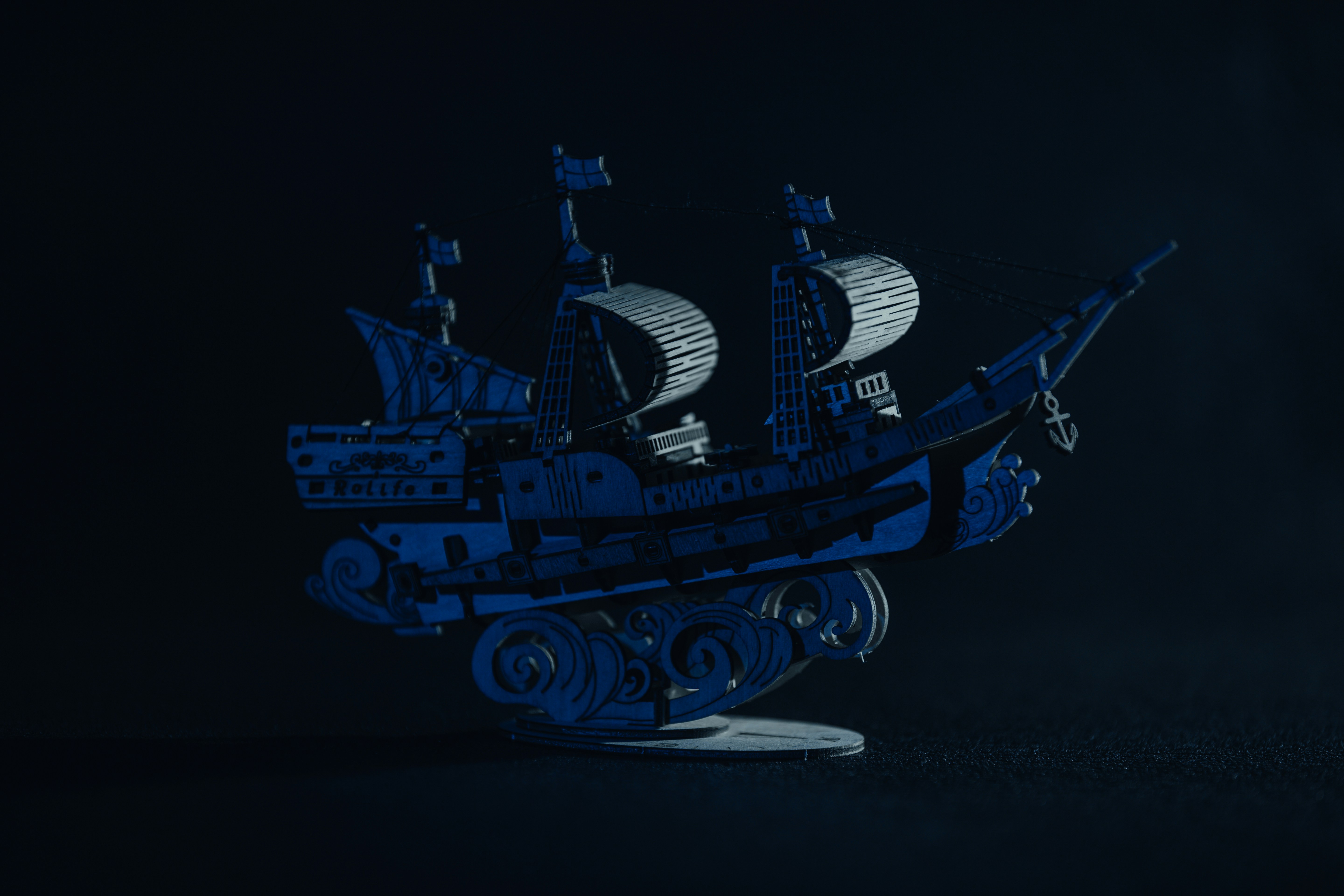 Blue model of a pirate ship on a black background