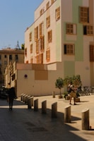 a man walking down a street next to a tall building