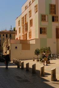 a man walking down a street next to a tall building