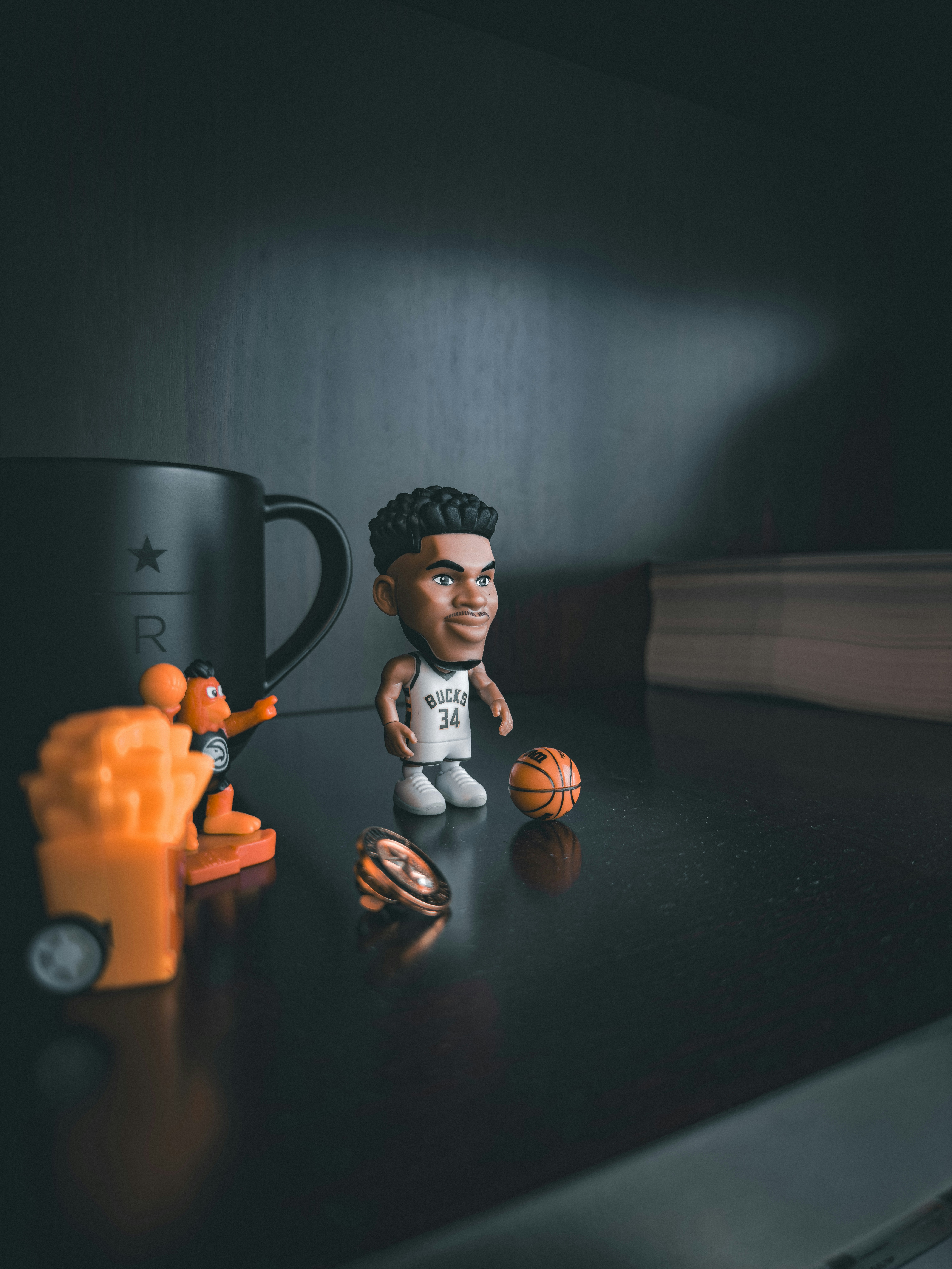 Sports memorabilia including basketball player bobblehead, championship ring, and NBA ball.