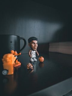 a figurine of a basketball player next to a coffee mug