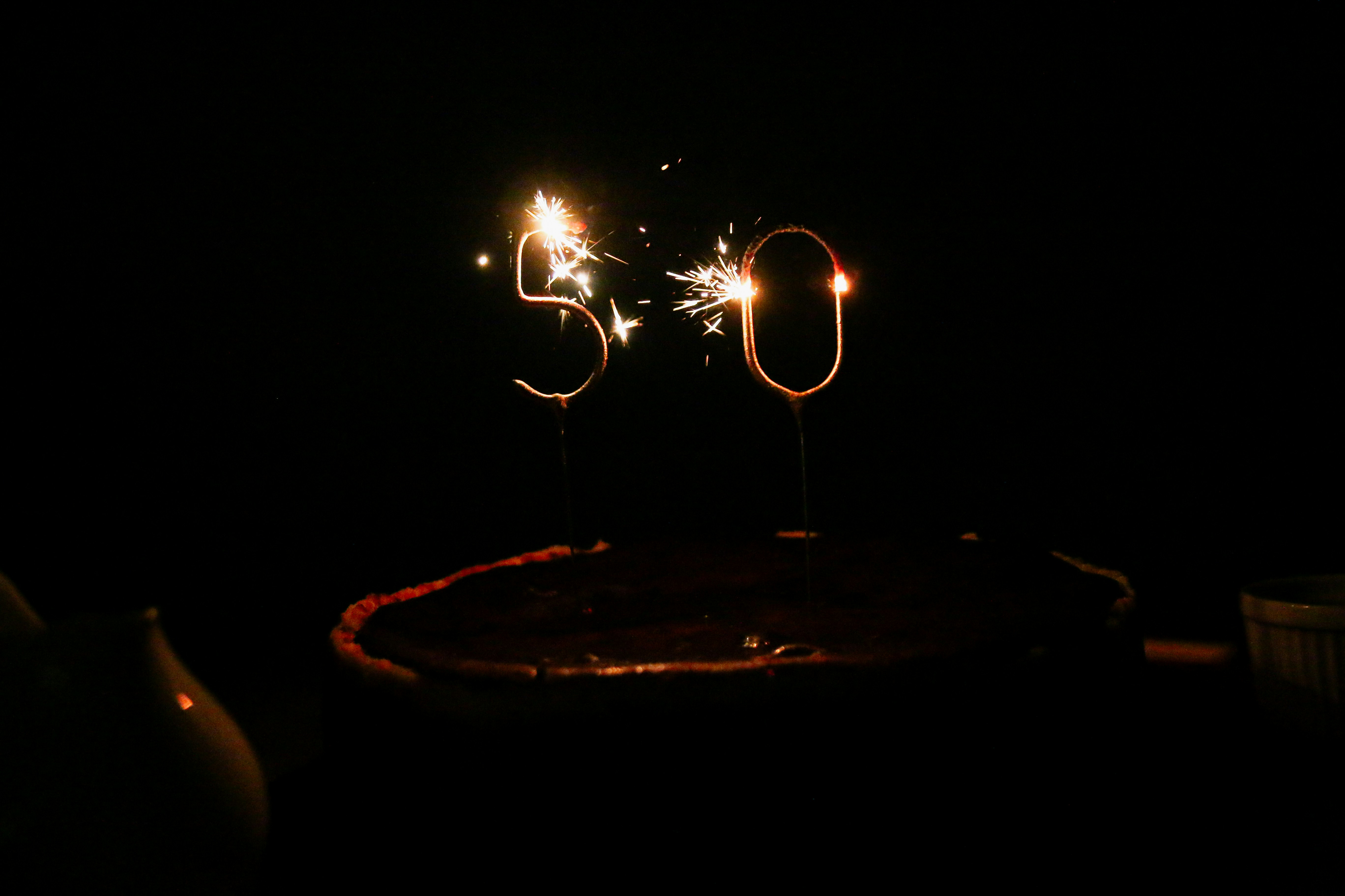 a birthday cake with sparklers in the shape of the number 50