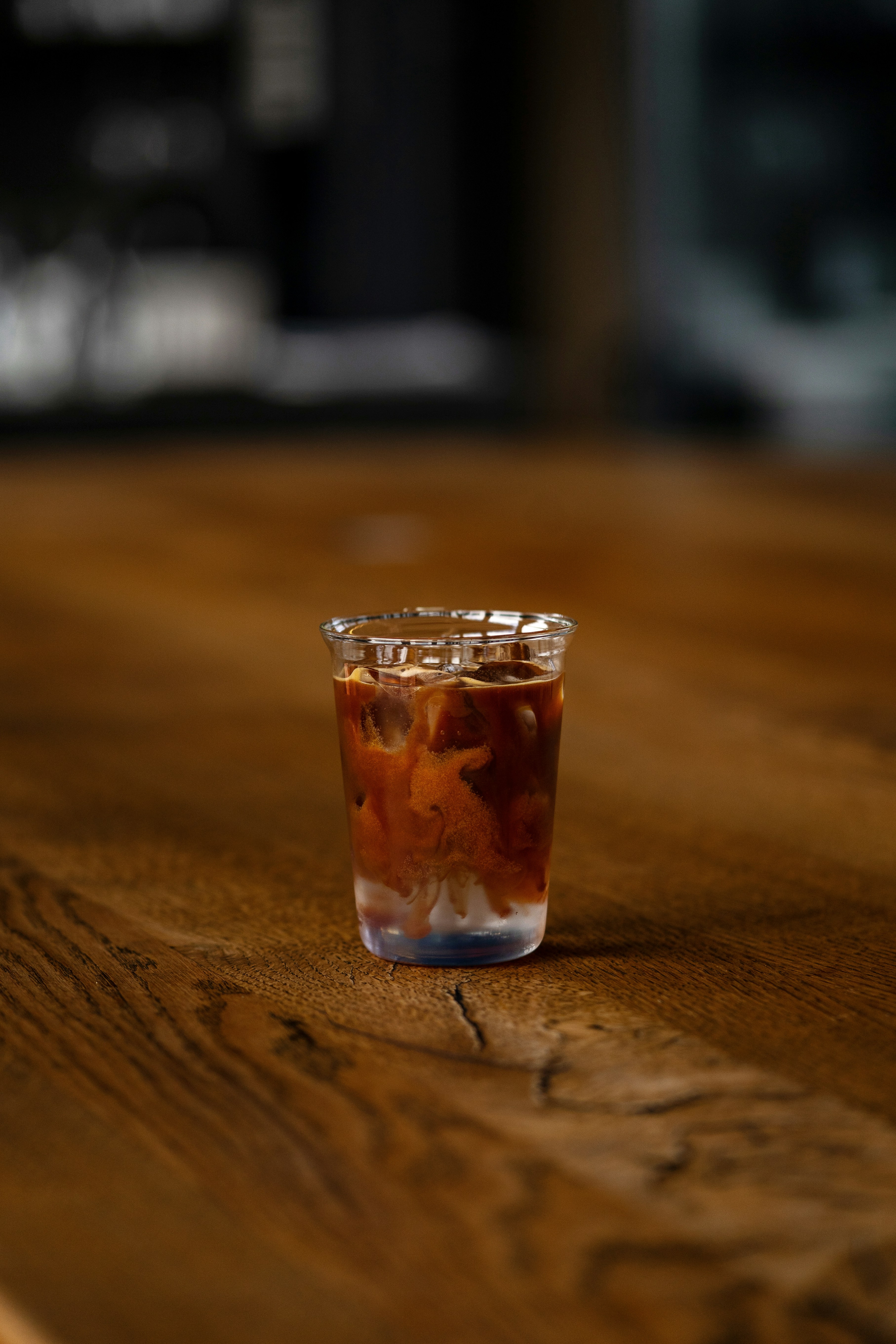 a shot glass filled with liquid sitting on a wooden table
