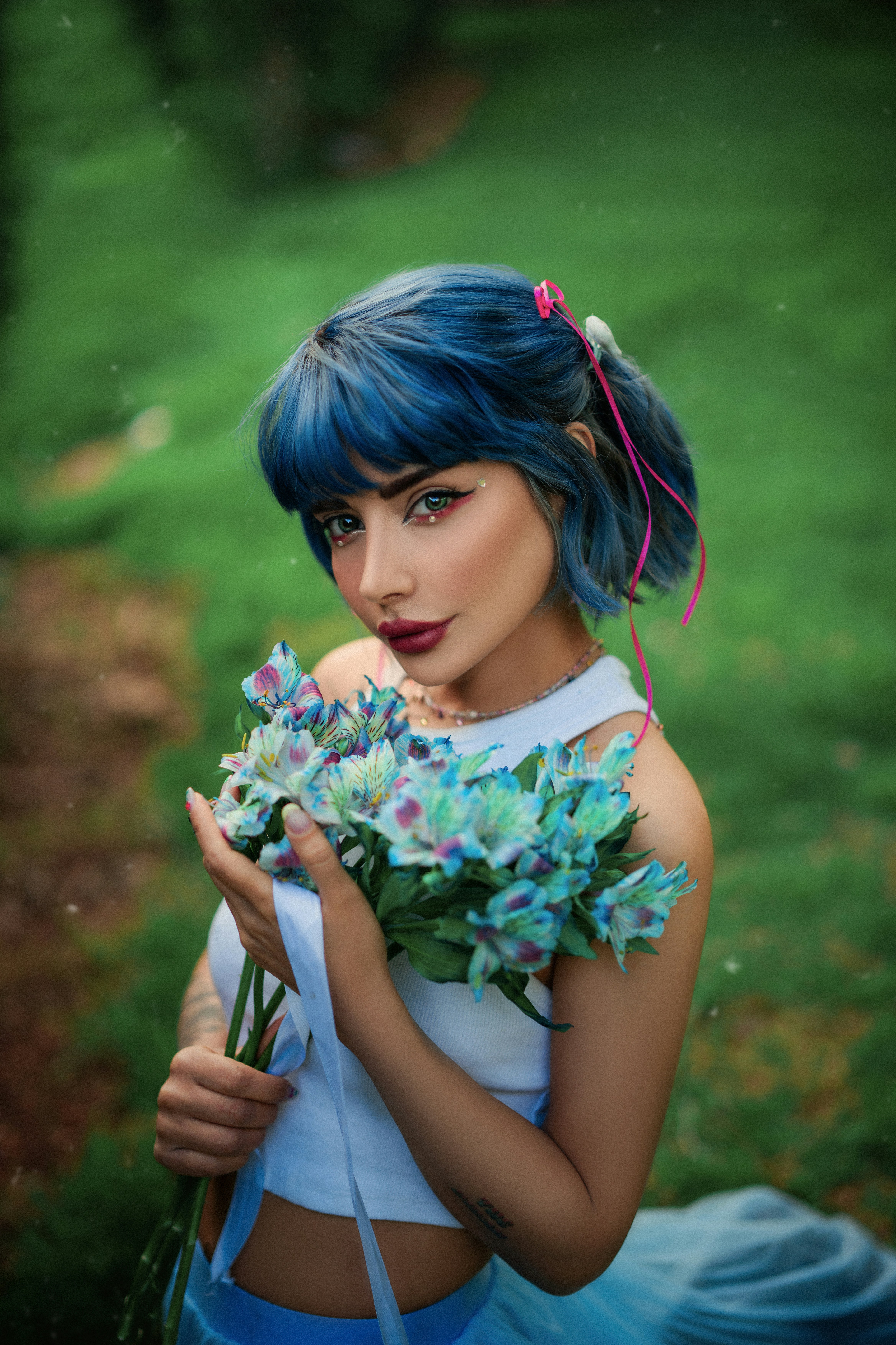 Seorang wanita berambut biru memegang buket bunga