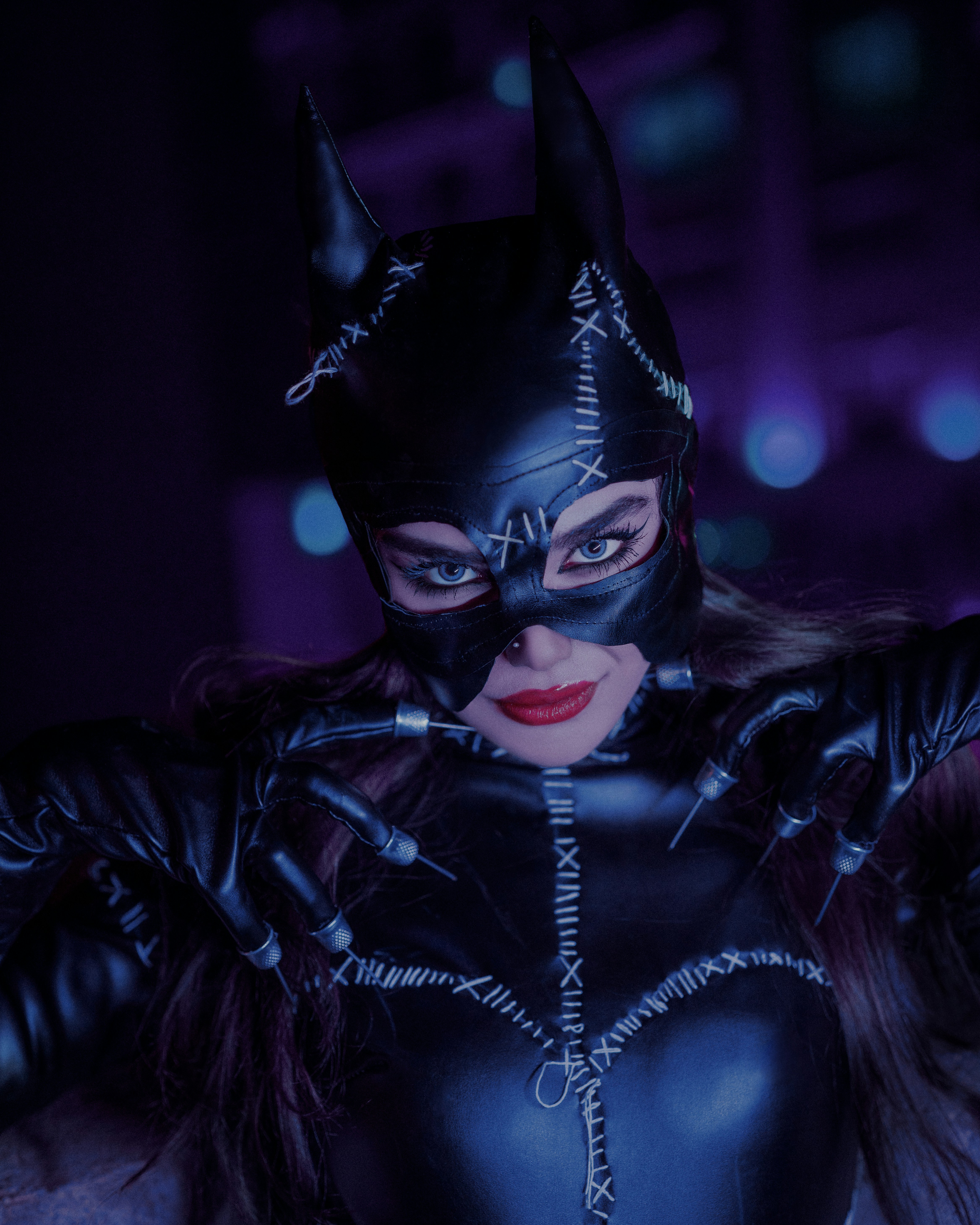Seorang wanita dengan kostum catwoman berpose untuk foto