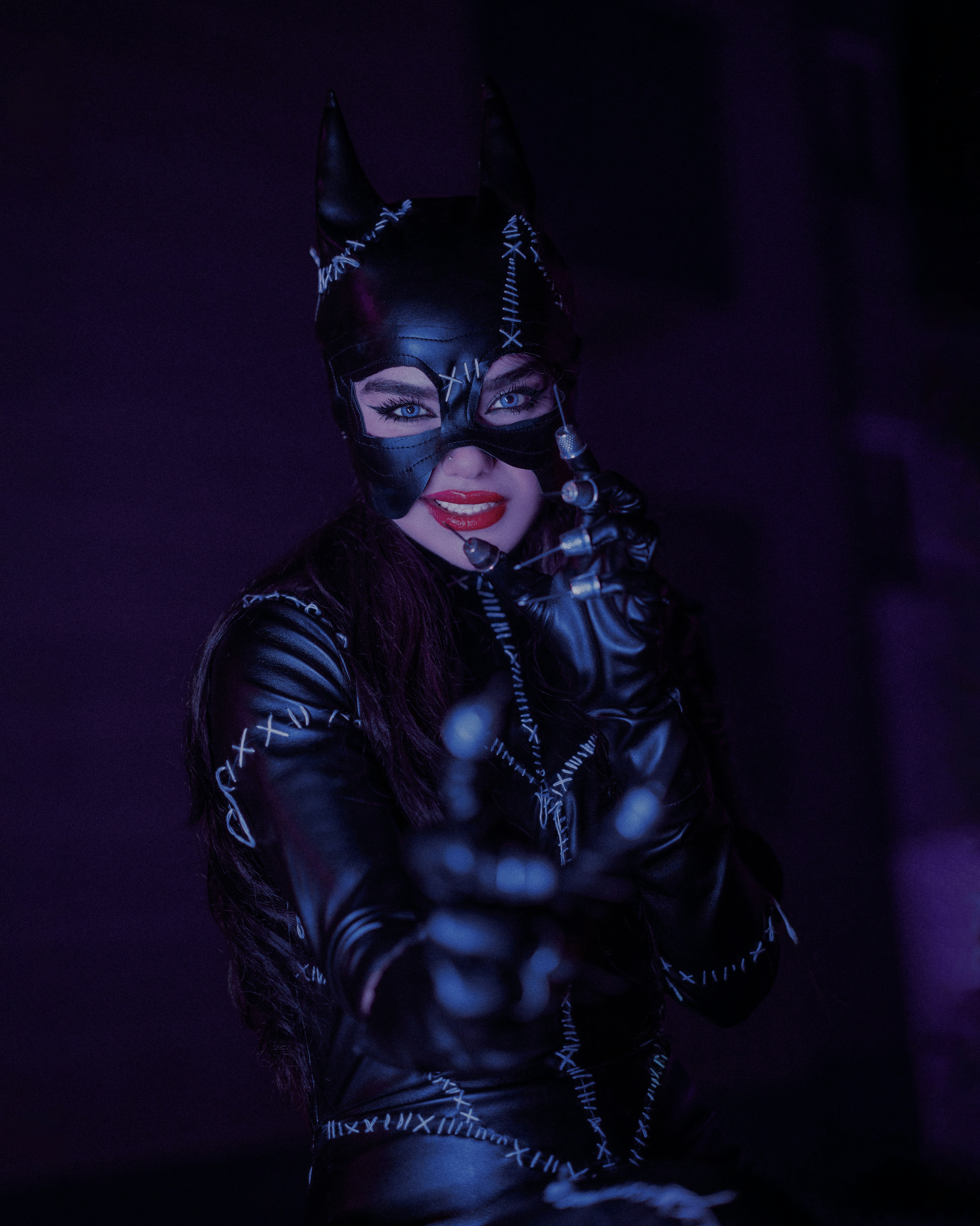 a woman dressed as a catwoman in a dark room