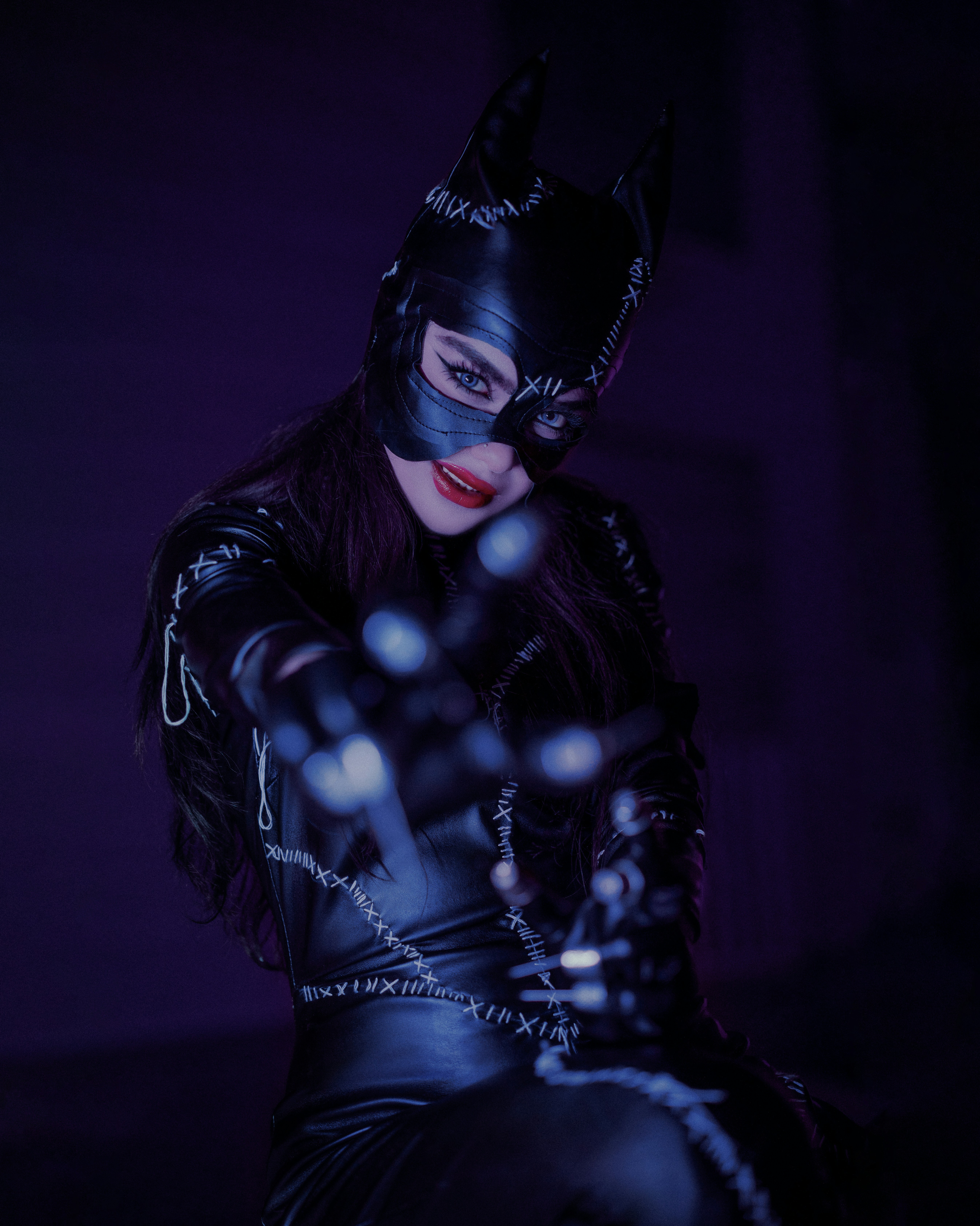 a woman dressed as a catwoman in a dark room