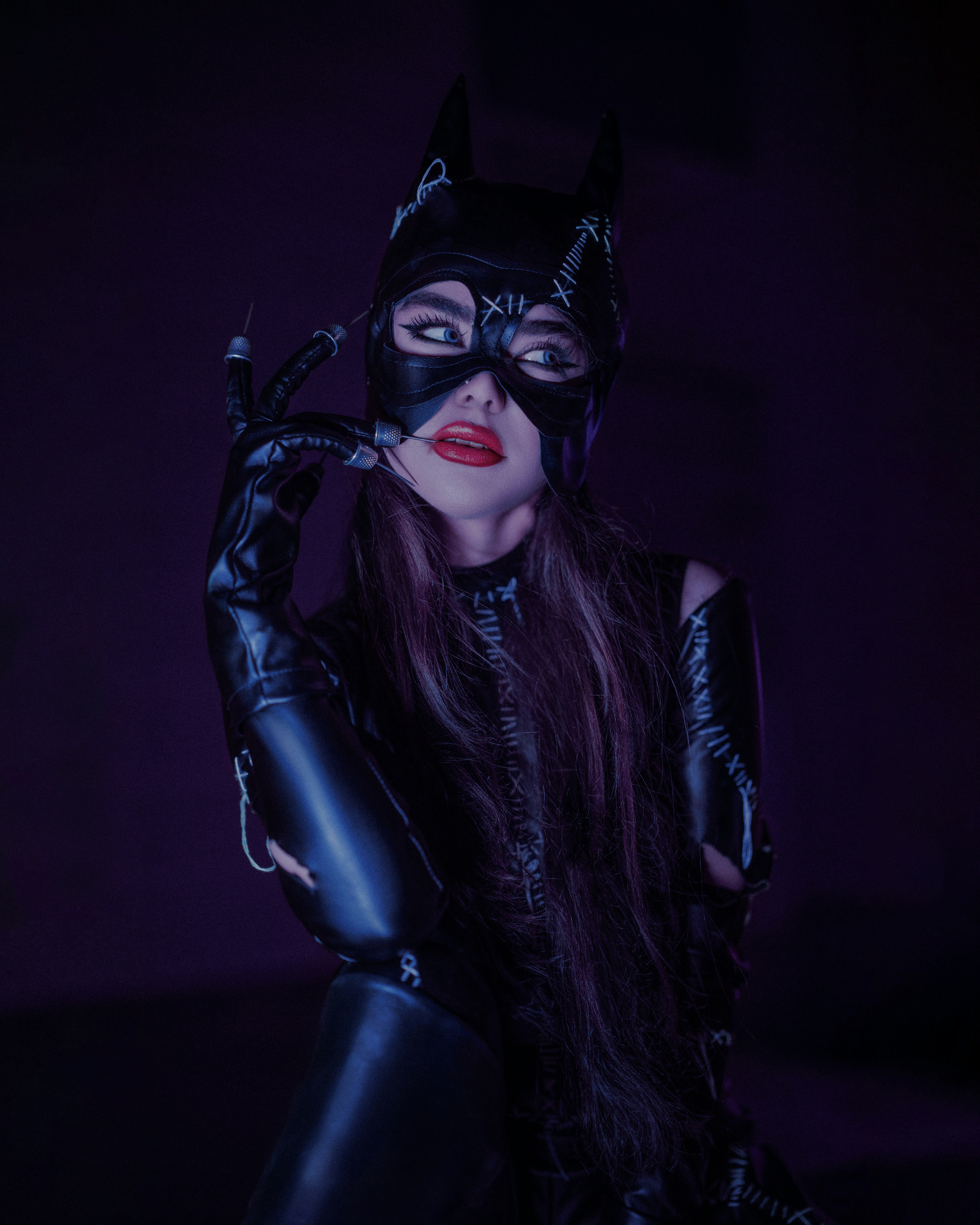 a woman wearing a cat mask and latex gloves