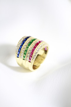 a gold ring with multicolored stones on it